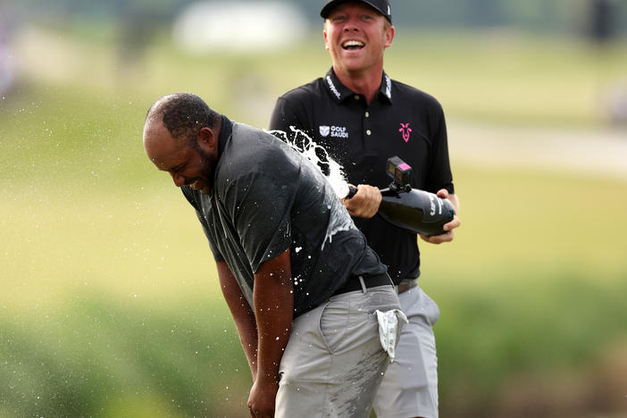 Harold Varner III (left) is doused by teammate Talor Gooch after Varner won the LIV Golf Invitational - DC at Trump National Golf Club on May 28, in Sterling, Va. The upstart tour will be united along with the PGA Tour, in a blockbuster merger.