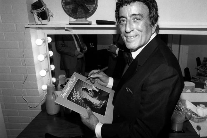 Tony Bennett poses while signing an autograph in 1988.