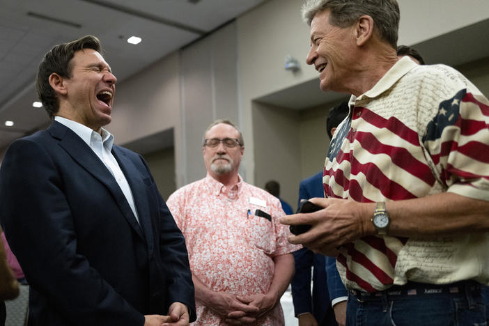 Florida Gov. Ron DeSantis (L) speaks with attendees during an Iowa GOP reception on May 13, 2023 in Cedar Rapids, Iowa.