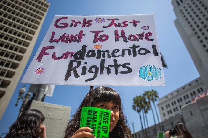 As more states pass abortion restrictions, confusion over terms shows up in hospitals and courtrooms. Camila Galvez holds a sign during a march for abortion rights in Los Angeles in April 2023.