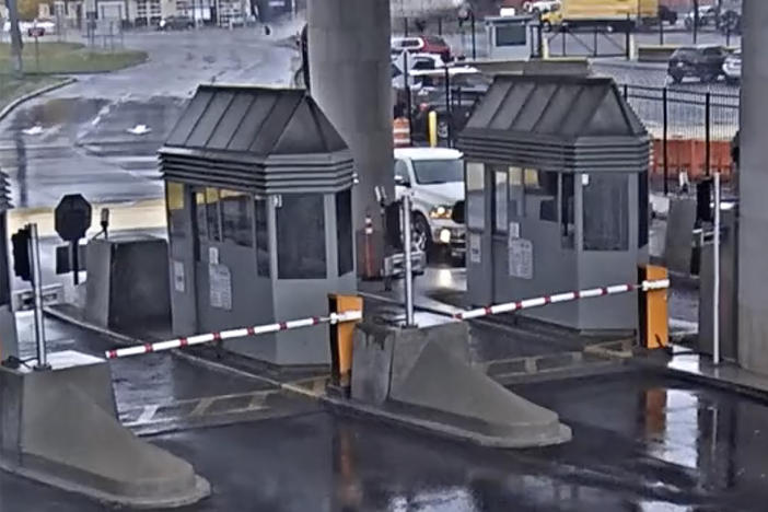 In this image taken from security video, a light-colored vehicle (top center) flies over a fence into the Rainbow Bridge customs plaza on Wednesday in Niagara Falls, N.Y.