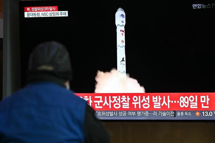 A man watches a television screen showing a news broadcast with a picture of North Korea's latest satellite-carrying rocket launch, at a railway station in Seoul on Nov. 22.