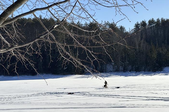An ice fisherman stands on the frozen Molly's Falls Pond in Marshfield, Vt., on Sunday.