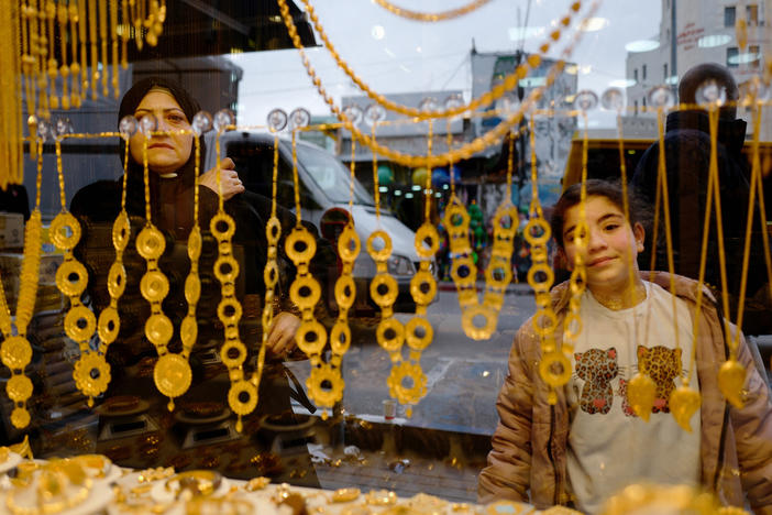 People in Ramallah look into the window of a gold store, one of the West Bank businesses affected by the economic decline resulting from Israel's war in Gaza.