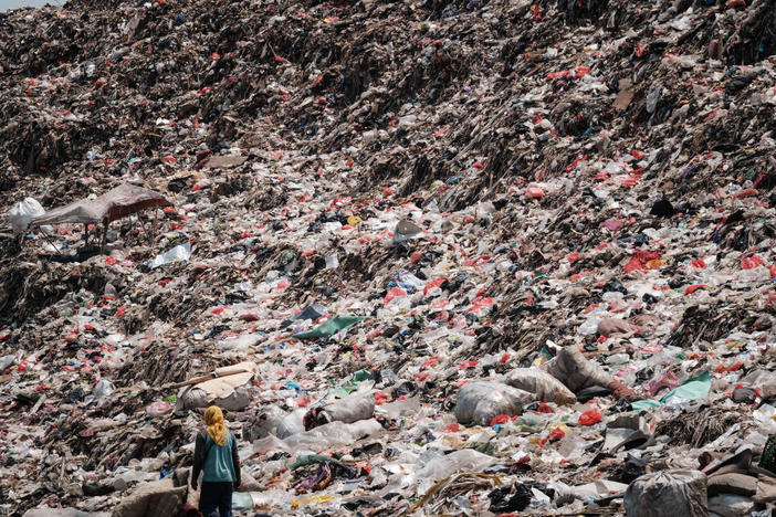 A registered scavenger, who mainly collects plastic waste to sell, walking in a landfill in Indonesia.