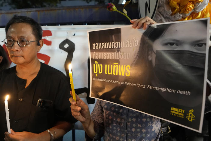 Thai activists hold a portrait of Netiporn Sanesangkhom, a member of the activist group Thaluwang outside of Criminal court in Bangkok, Thailand, on Tuesday.