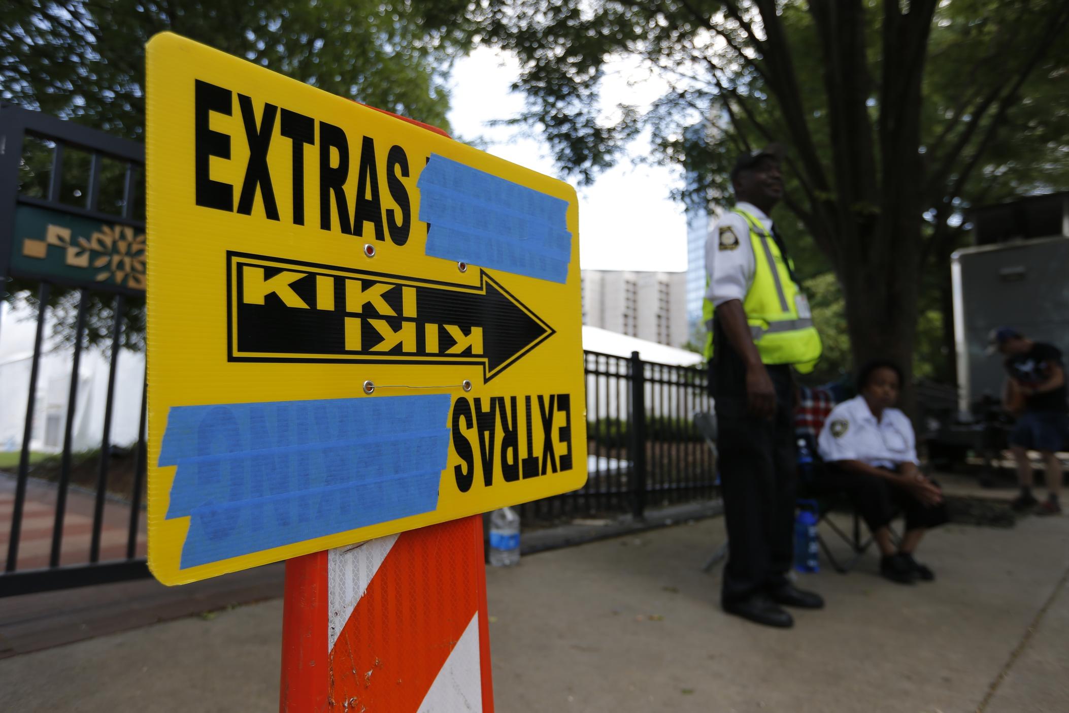 In this Thursday, July 25, 2019 photo, security guards are posted near an entrance to Centennial Olympic Park in downtown Atlanta where a sign for movie extras is set up.
