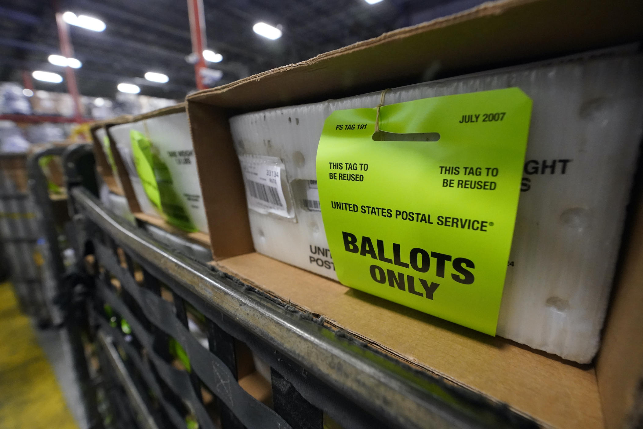 A cart holding vote-by-mail ballots is seen before being loaded into a truck for transport to a local U.S. Postal Service office, Thursday, Oct. 1, 2020, at the Miami-Dade County Elections Department in Doral, Fla. 