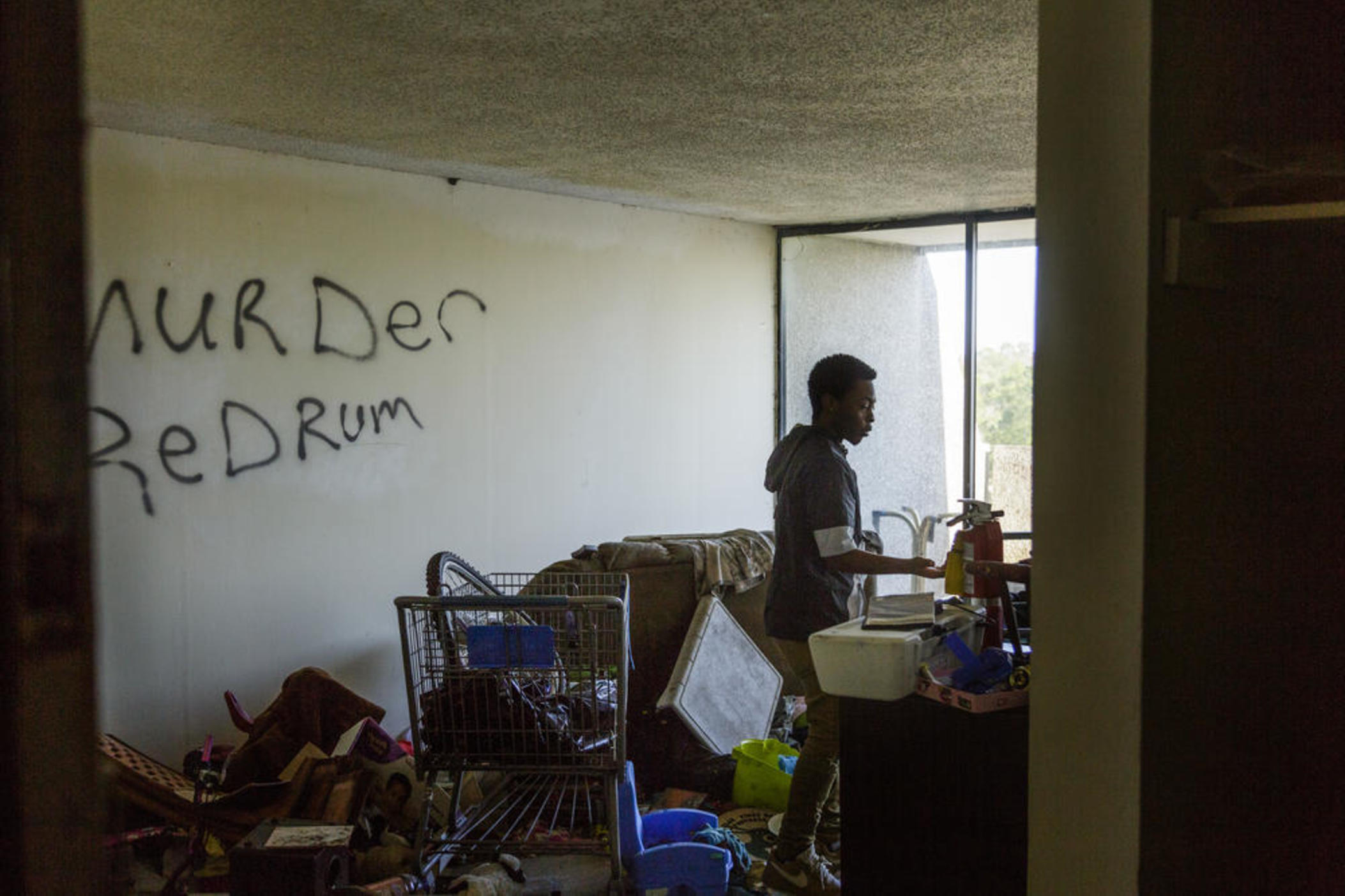 Darrell Osgood walks through a squat down the hall from his apartment in Macon. Despite utilities rolled into rent, management recently let the water get cut off. It's only the latest indignity that has residents wanting to talk to corporate.