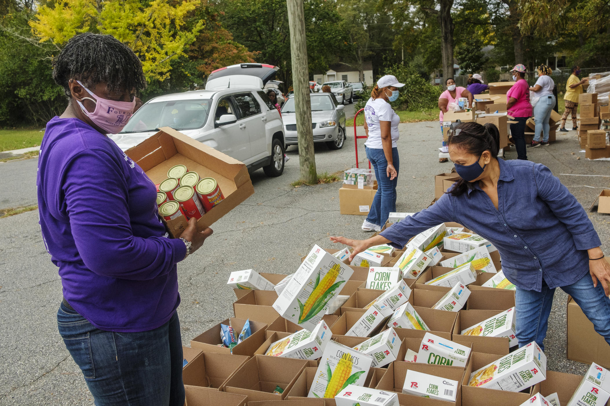 Volunteers, mostly from the Single Moms Connect support group, prepare grocery boxes during one of the group's twice monthly food disbursals in Houston County. 