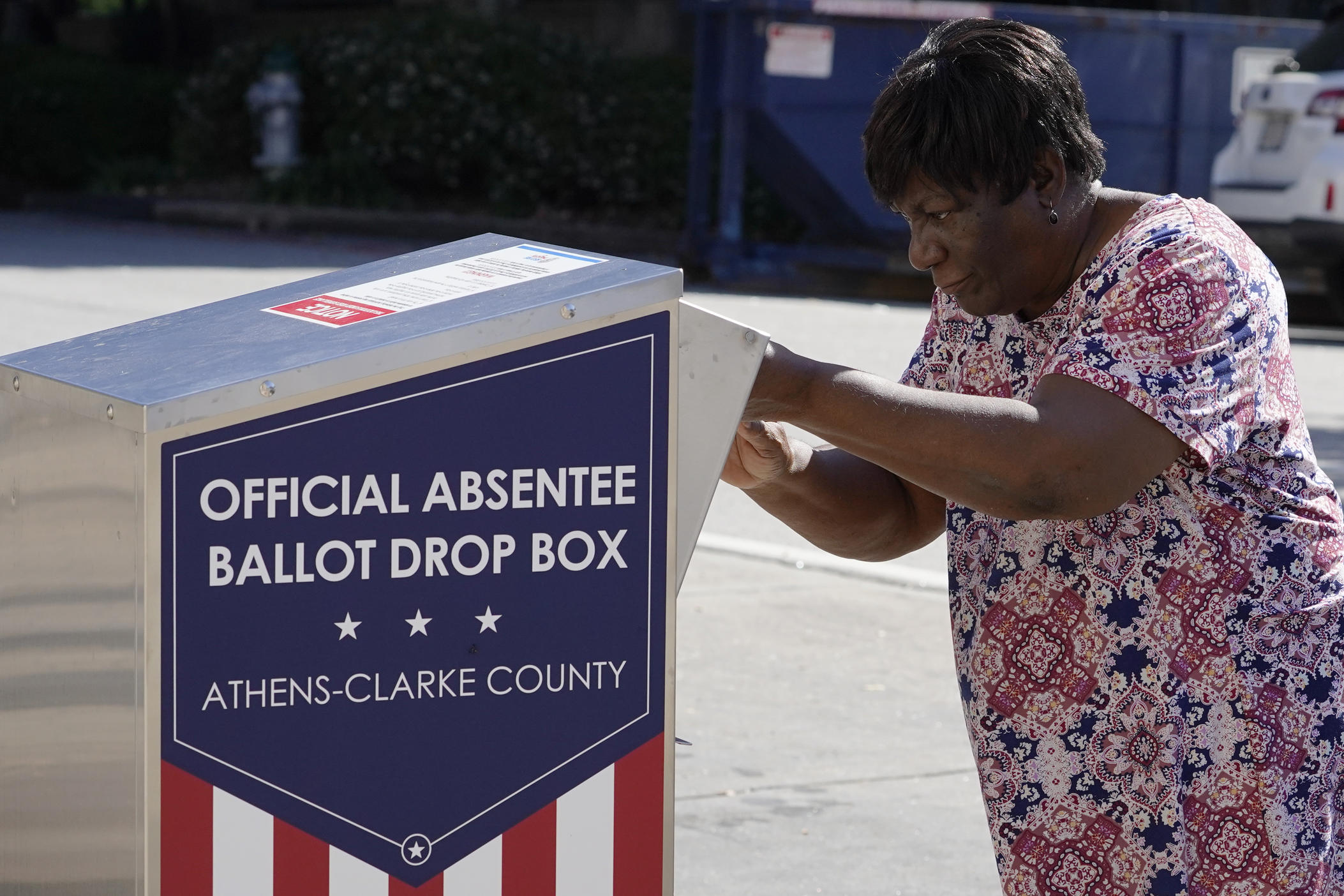 A voter drops their ballot off during early voting, Monday, Oct. 19, 2020, in Athens, Ga. 