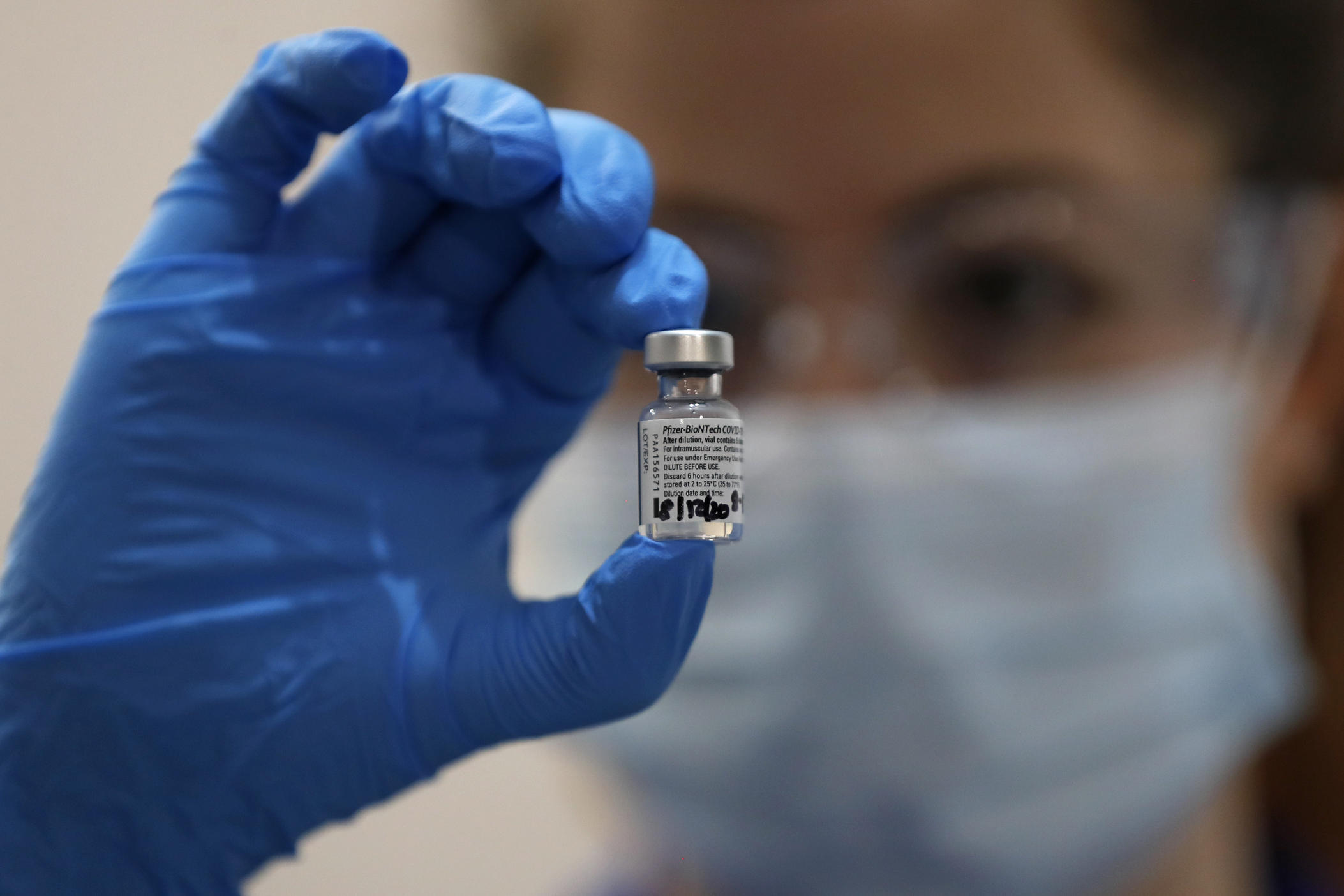A nurse holds a vial of Pfizer's COVID-19 vaccine