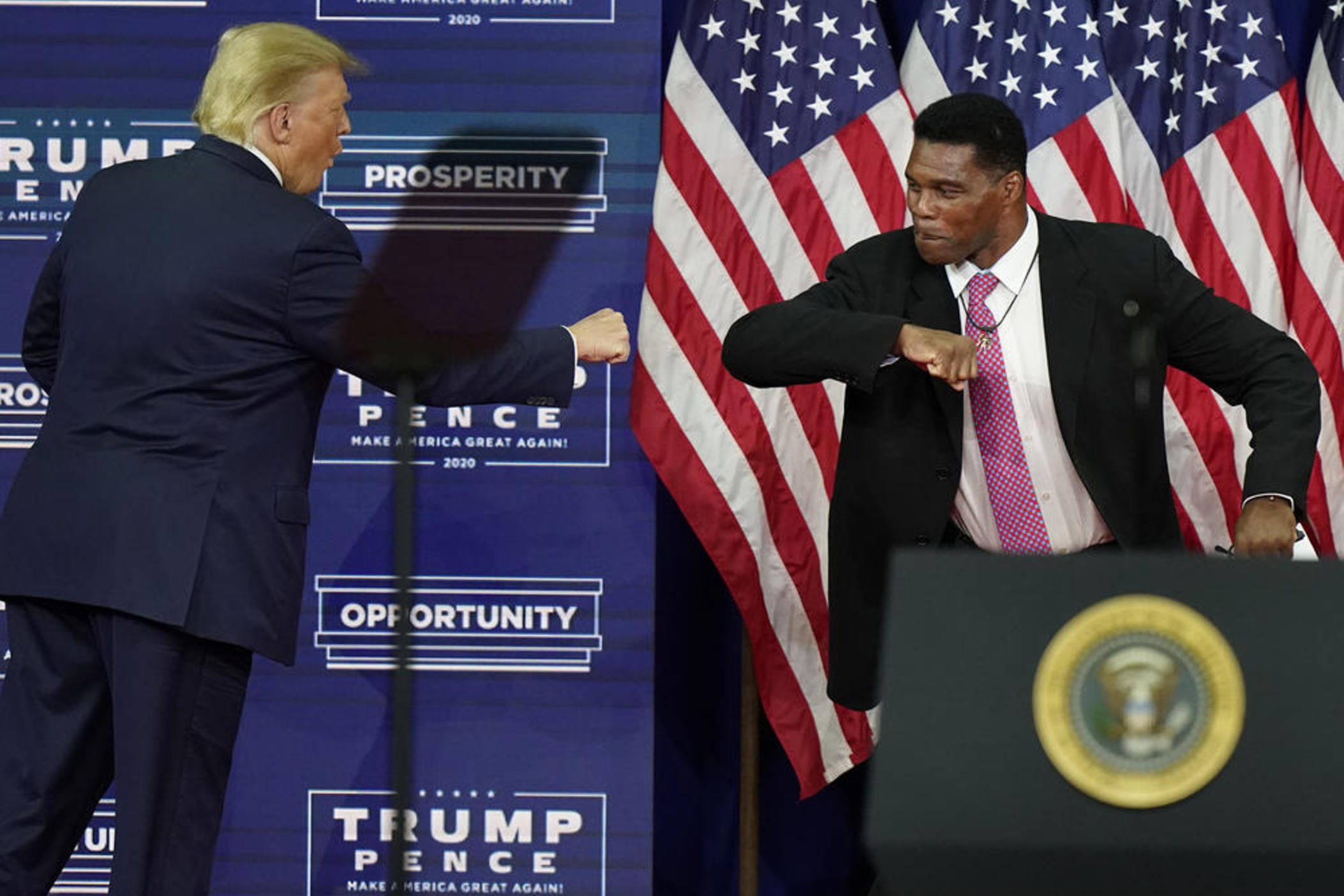 Then-President Donald Trump elbow bumps Herschel Walker during a 2020 campaign rally in Atlanta. Walker filed paperwork Tuesday to run for U.S. Senate in the key swing state of Georgia.