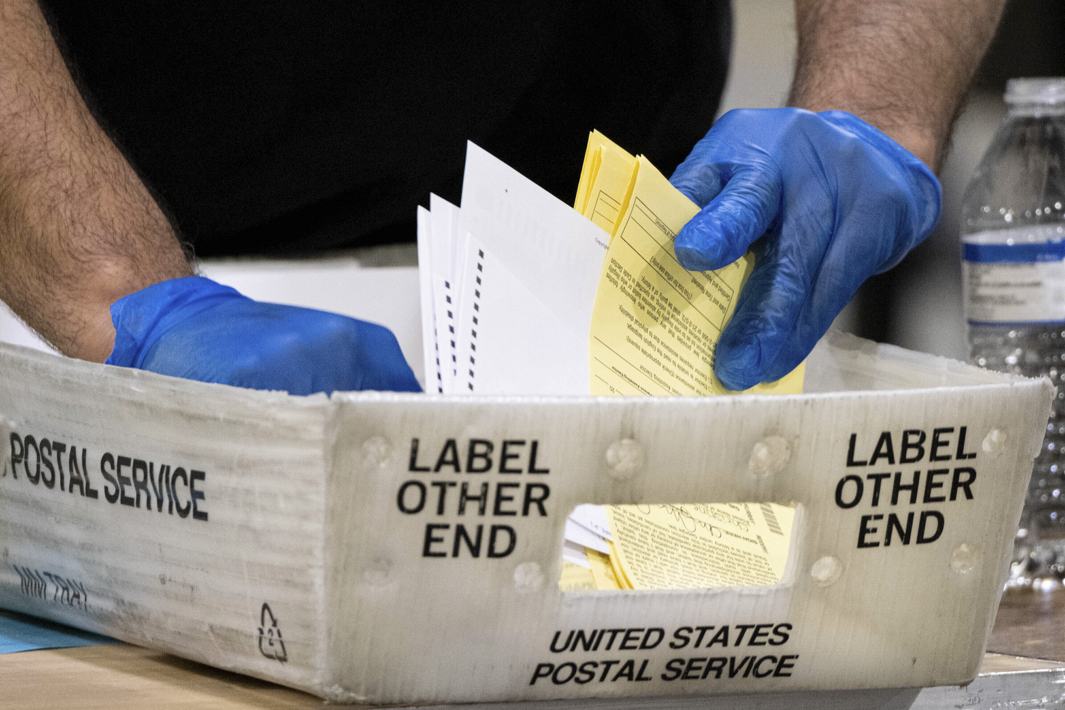 In this Jan. 5, 2021, file photo, Fulton County Georgia elections workers process absentee ballots for the Senate runoff election in Atlanta. On Monday, June 21, 2021, a judge is set to hear arguments over whether a lawsuit that alleges fraud during the November general election in Georgia’s most populous county should be dismissed. (AP Photo/Ben Gray, File) 