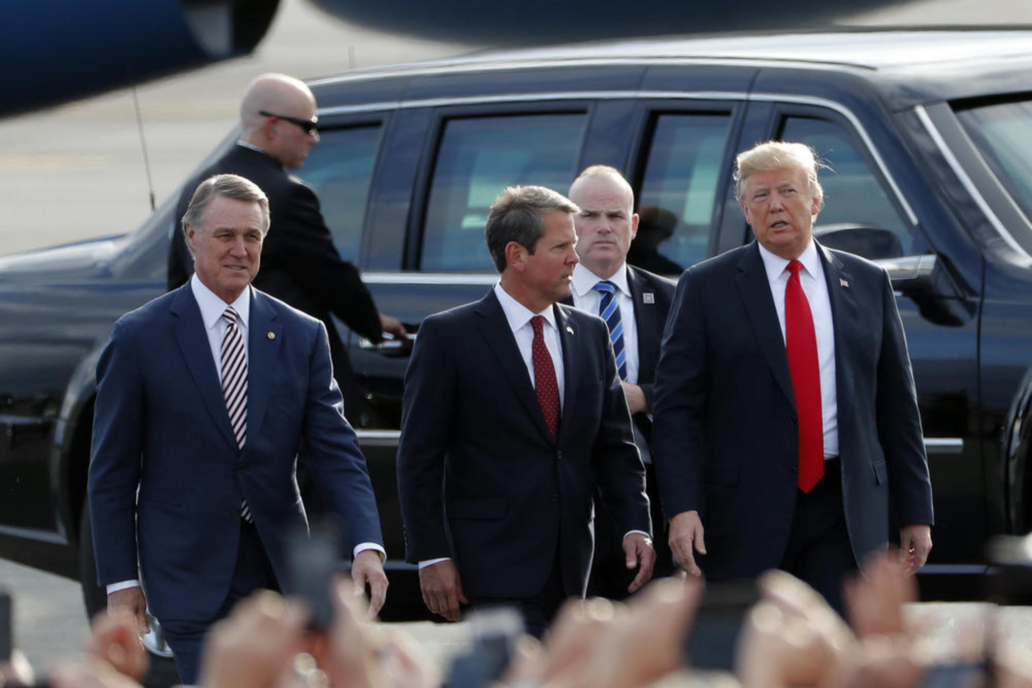 Georgia Republican gubernatorial candidate Brian Kemp, center, walks with President Donald Trump, right, and Sen. David Perdue (R-Ga) as Trump arrives for a rally Sunday, Nov. 4, 2018, in Macon, Ga. Credit: John Bazemore, AP