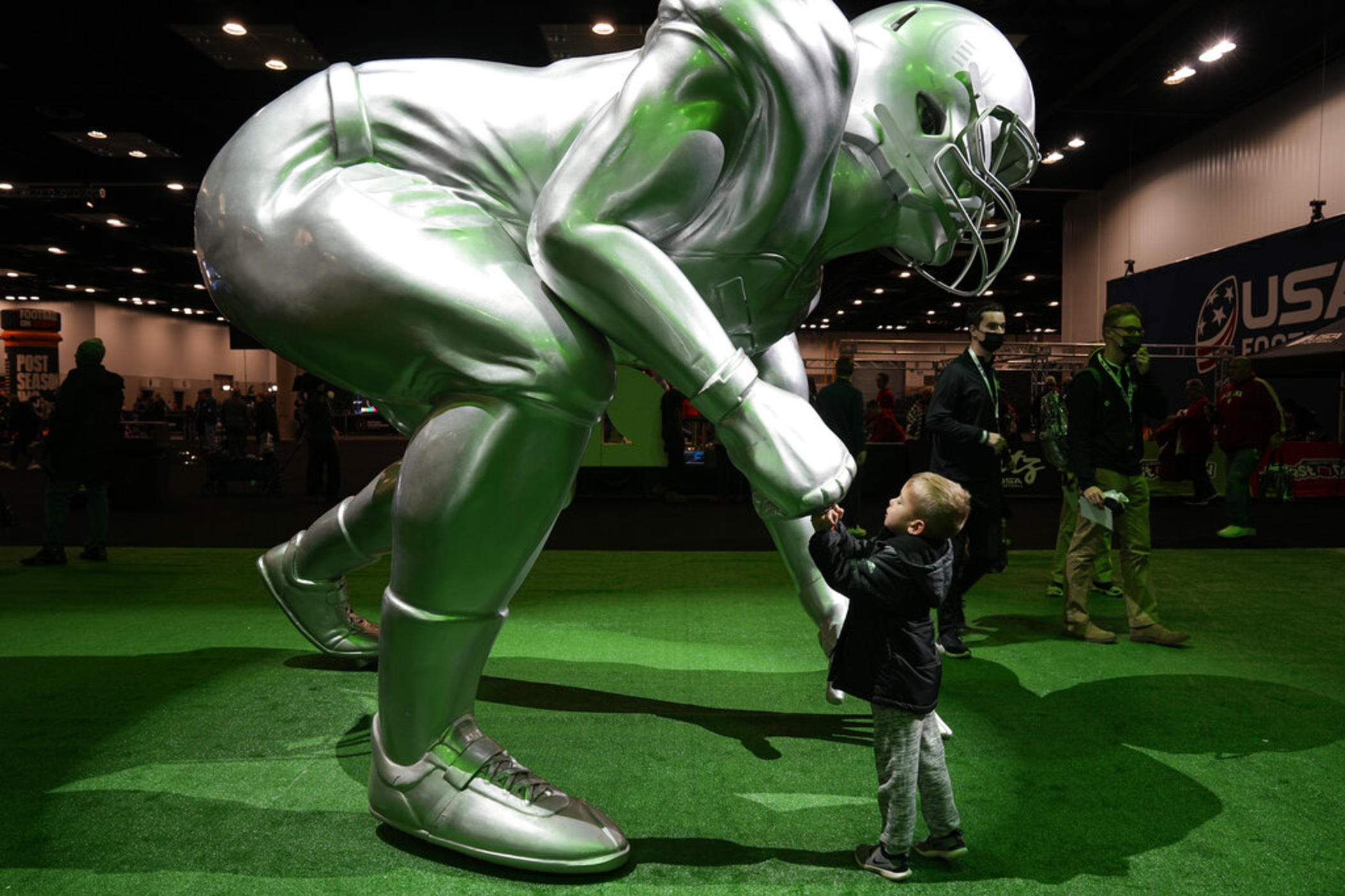 A child fist bumps a statue in Indianapolis, Saturday, Jan. 8, 2022. Alabama plays Georgia in the NCAA college football championship game on Monday.