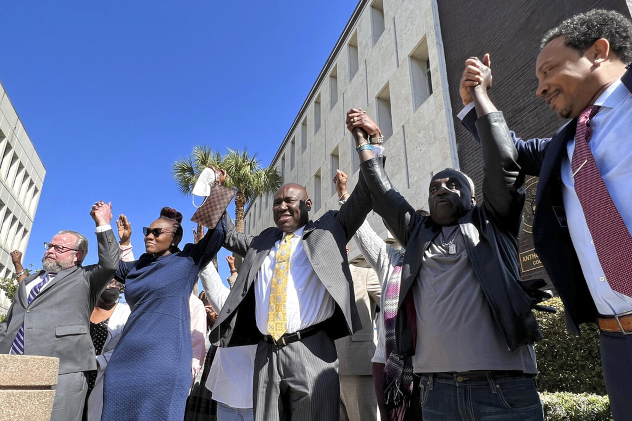 The family of Ahmaud Arbery and attorneys representing his case raise their arms in victory after all three men were found guilty of hates crimes at the federal courthouse in Brunswick, Ga., on Tuesday, Feb. 22, 2022. Greg McMichael, Travis McMichael and William “Roddie” Bryan, the three men convicted of murder in Arbery’s fatal shooting have been found guilty of federal hate crimes.