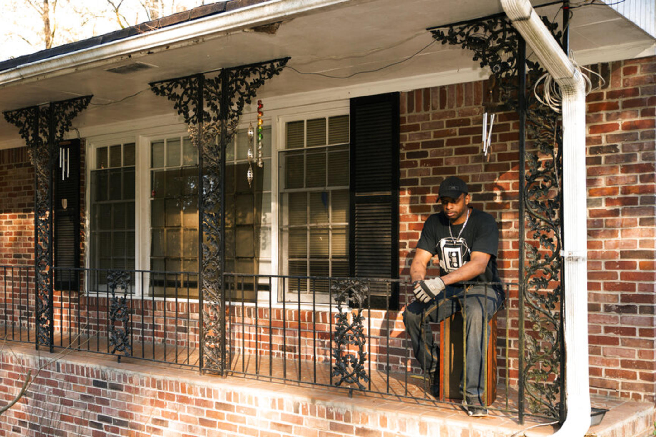Prince Beatty takes a seat on a broken speaker outside on the front porch of his home in East Point, Ga. Beatty, a 47-year-old Navy veteran, faces eviction this month for unpaid rent despite his landlord getting more than $20,000 in federal rental assistance.