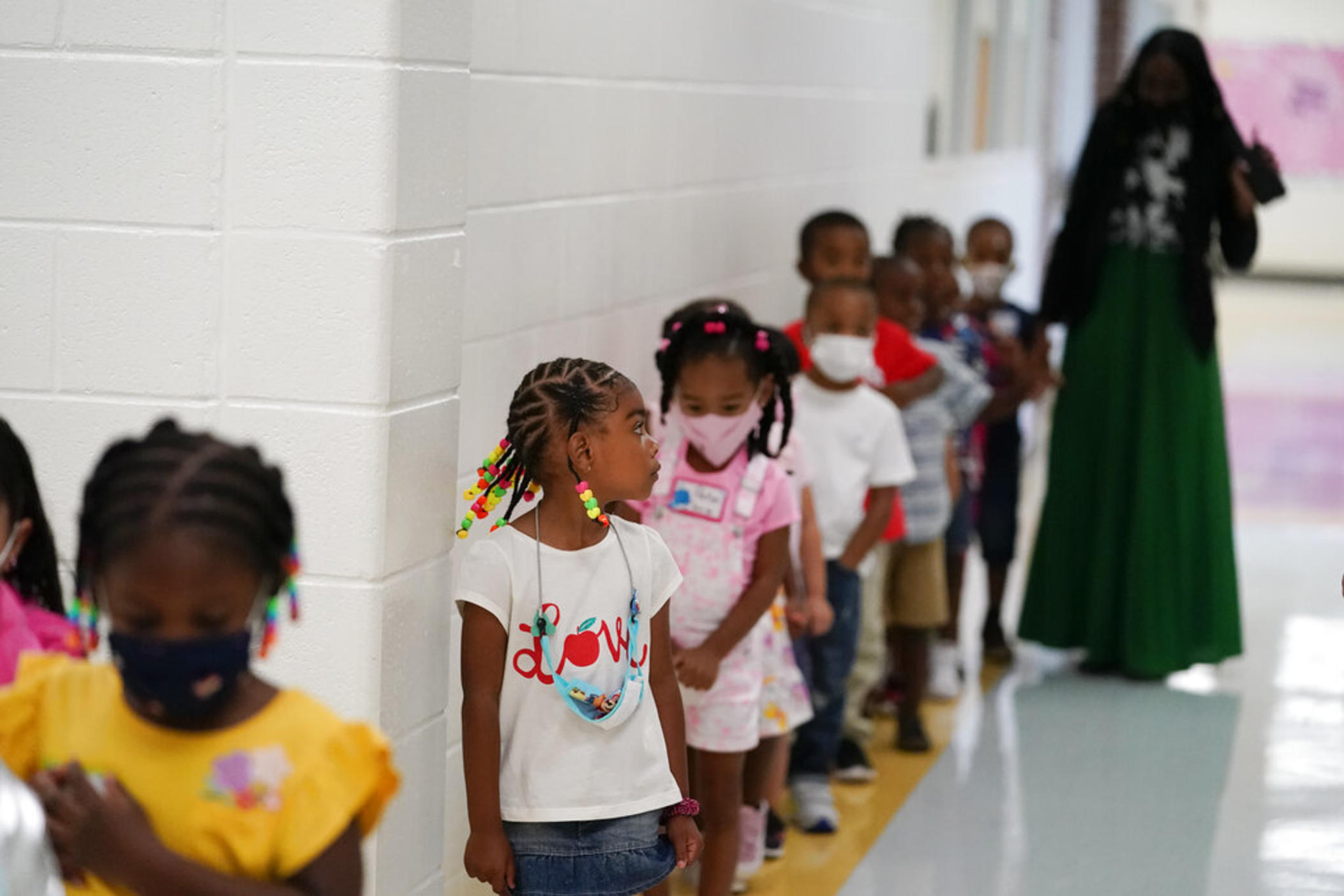 Students walk down the hallway at Tussahaw Elementary school on Wednesday, Aug. 4, 2021, in McDonough, Ga., with some in masks and some unmasked. Gov. Brian Kemp on Wednesday, Feb. 9, 2022, said he would propose a law that would let parents opt their students out of masks in Georgia school districts that require them for all students to prevent the spread of COVID-19.
