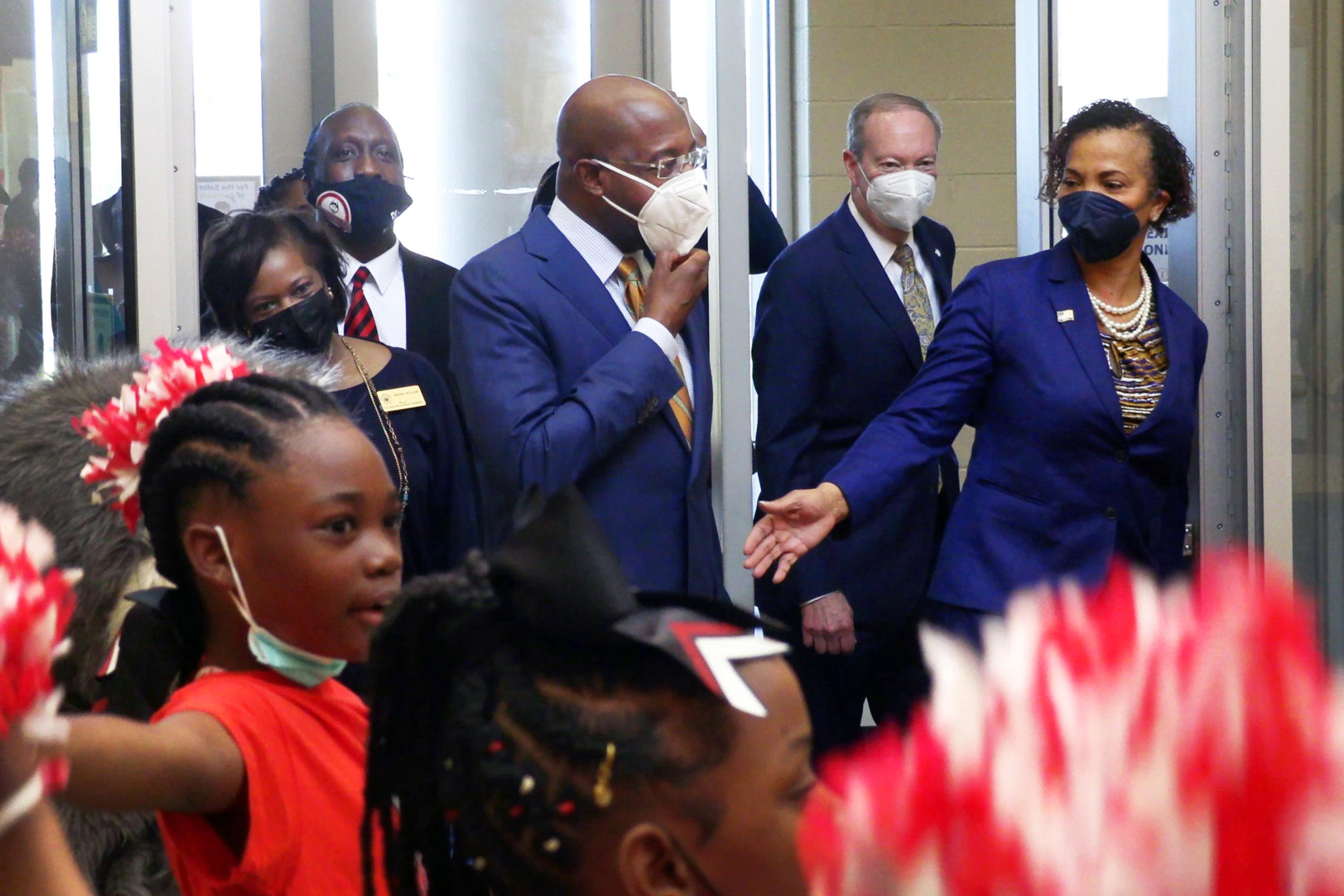 U.S. Sen. Raphael Warnock, second from center, arrives Tuesday morning at Dorothy Height Elementary School in Columbus, Georgia.