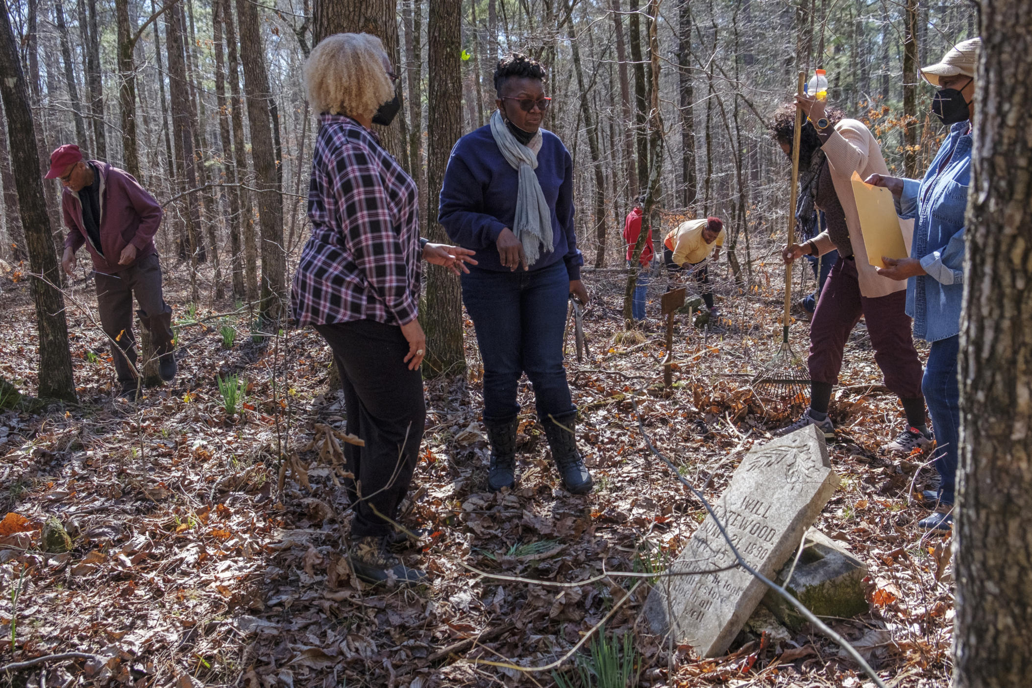 Fannie Rowe, center right, leads a group on a search in the original Bethel Bara Missionary Baptist Church cemetery in the Oconee National Forest near Greensboro recently. Rowe found the grave of her great-great-grandfather, who was born into slavery but died emancipated. 