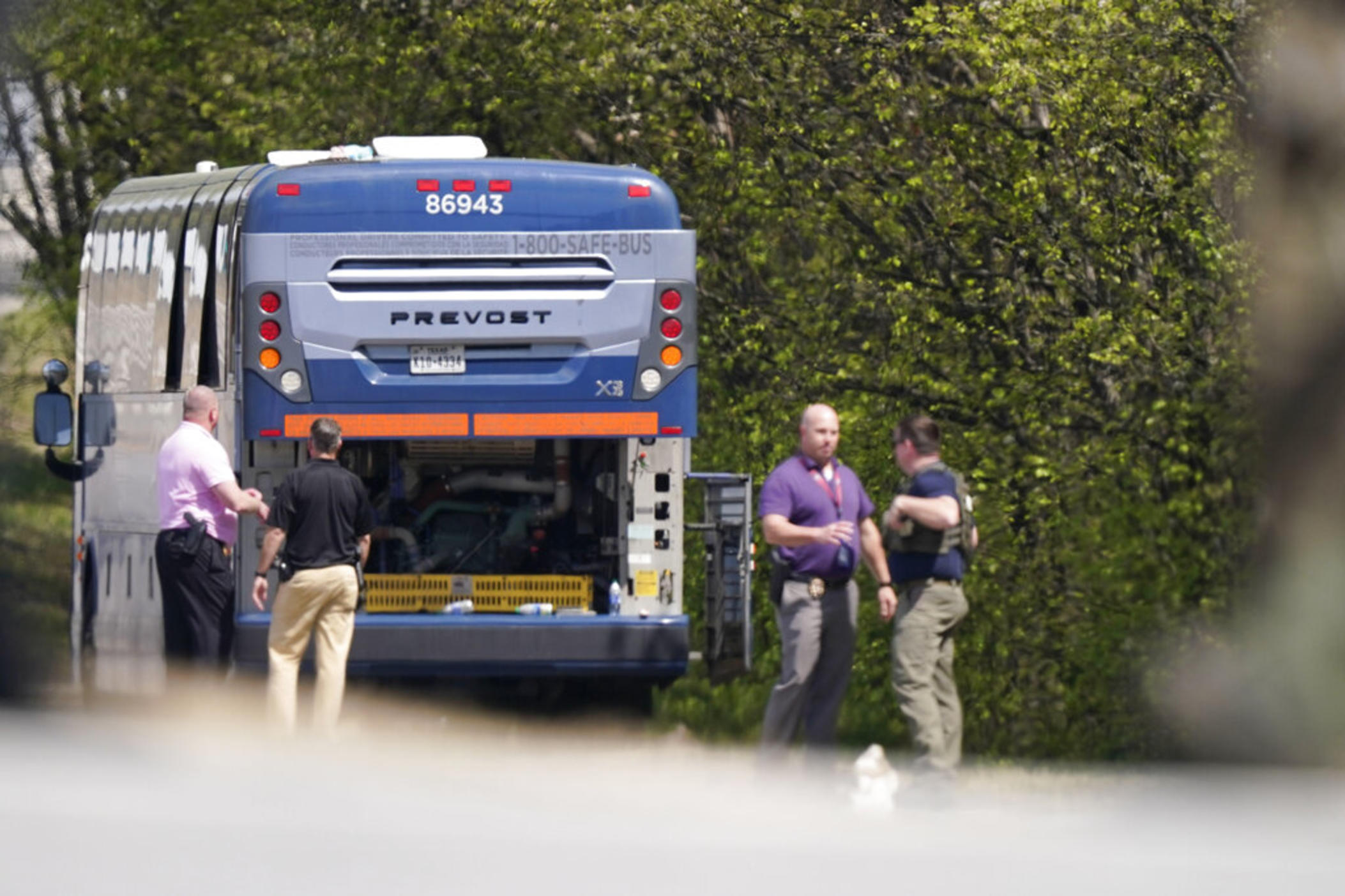 Authorities work the scene of a standoff with a person who is armed with a gun aboard a Greyhound bus on Tuesday, March 22, 2022, in Norcross, Ga. The police tactics team has surrounded the bus along a major interstate northeast of Atlanta, prompting the highway to close in both directions for more than four hours.