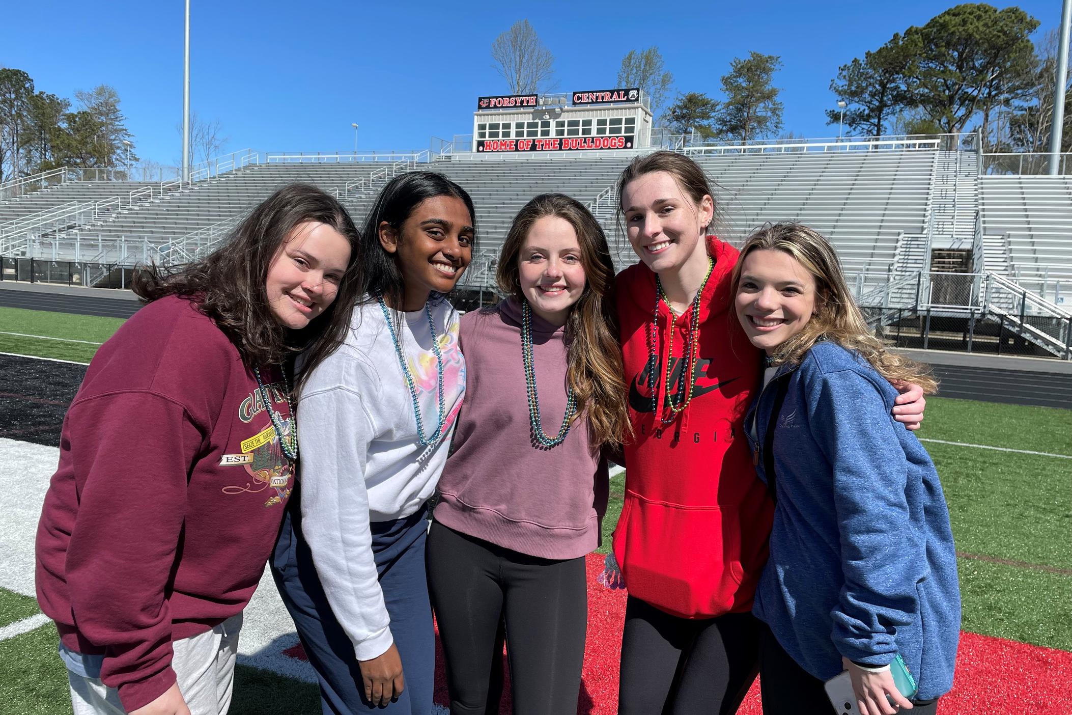 A group of five Forsyth County high school students gather at the Forsyth Central High School track for an Out of the Darkness walk March 26, 2022, including the event's organizer, Ali Norris (center).