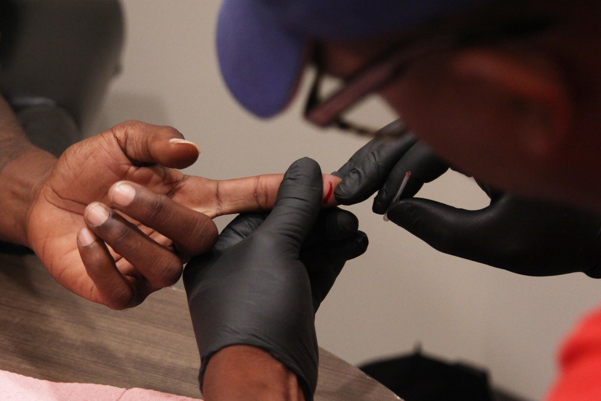 DeMarcus Beckham, HIV/AIDS advocate in the North Central Public Health district, performs a demonstration of an HIV test at a clinic in Macon. Rapid HIV blood tests take less than five minutes for results.