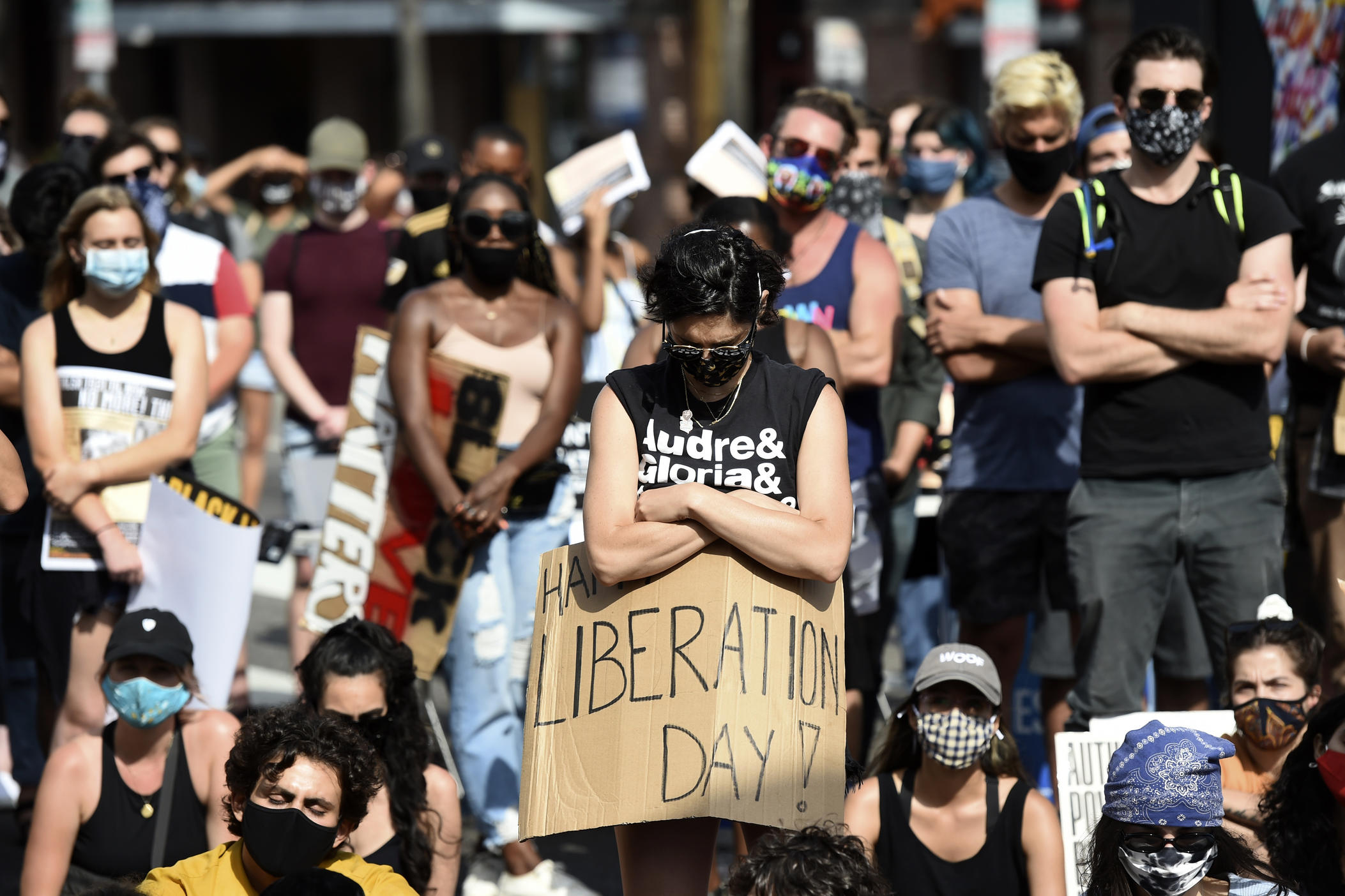 An attendee takes part in a moment of silence at a Juneteenth forum, Friday, June 19, 2020, outside the Laugh Factory comedy club in Los Angeles. Juneteenth marks the day in 1865 when federal troops arrived in Galveston, Texas, to take control of the state and ensure all enslaved people be freed, more than two years after the Emancipation Proclamation.