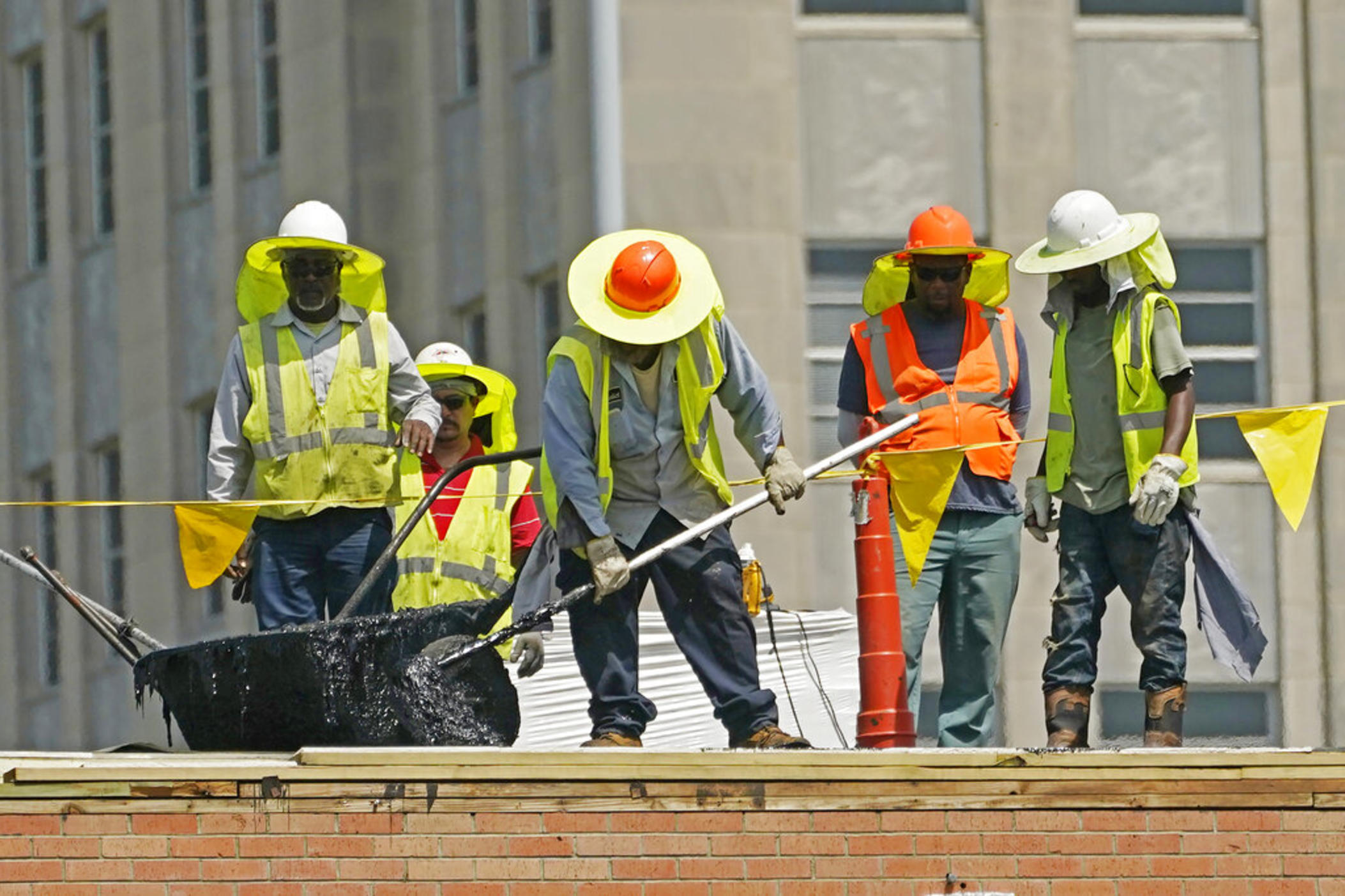 Workers brave the oppressive heat in Jackson, Miss., as they reroof the Barfield Complex, Monday, June 13, 2022. Heat advisories, excessive heat warnings and excessive heat watches were issued over states stretching through parts of the Gulf Coast to the Great Lakes and east to the Carolinas. 