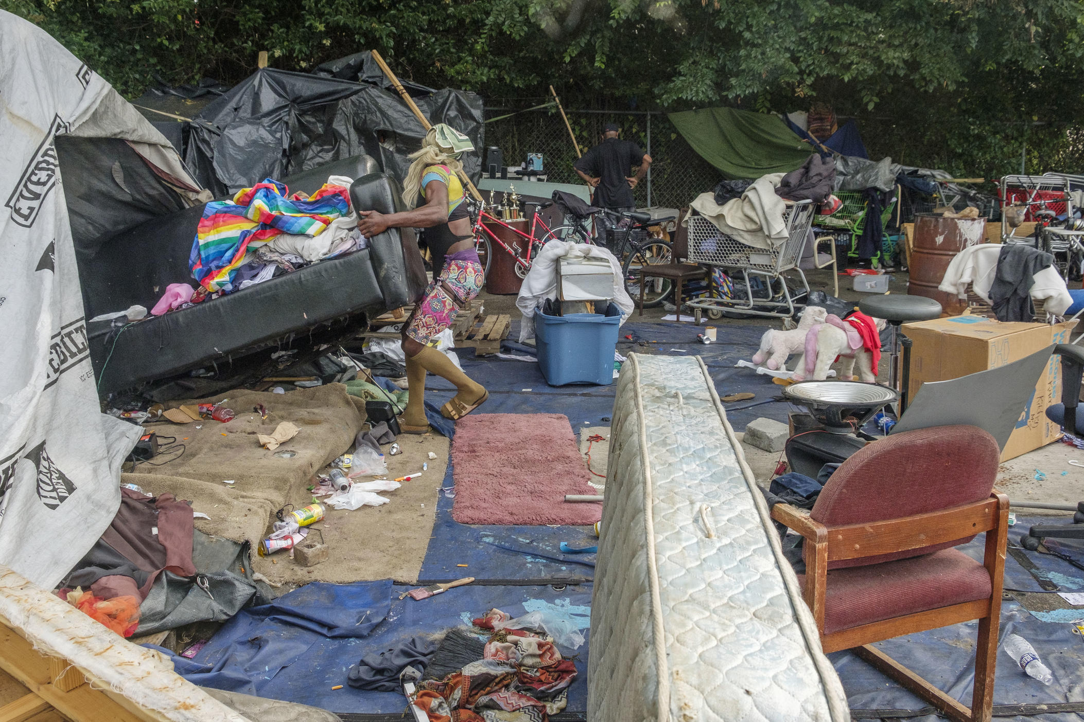 A resident of the Macon homeless encampment between downtown and Interstate 16 struggles to move a couch from their tent before a bulldozer rolls to take it away on June 8, 2022. Macon-Bibb County bulldozed one of the city's largest homeless encampments, saying it was necessary as a public health measure.