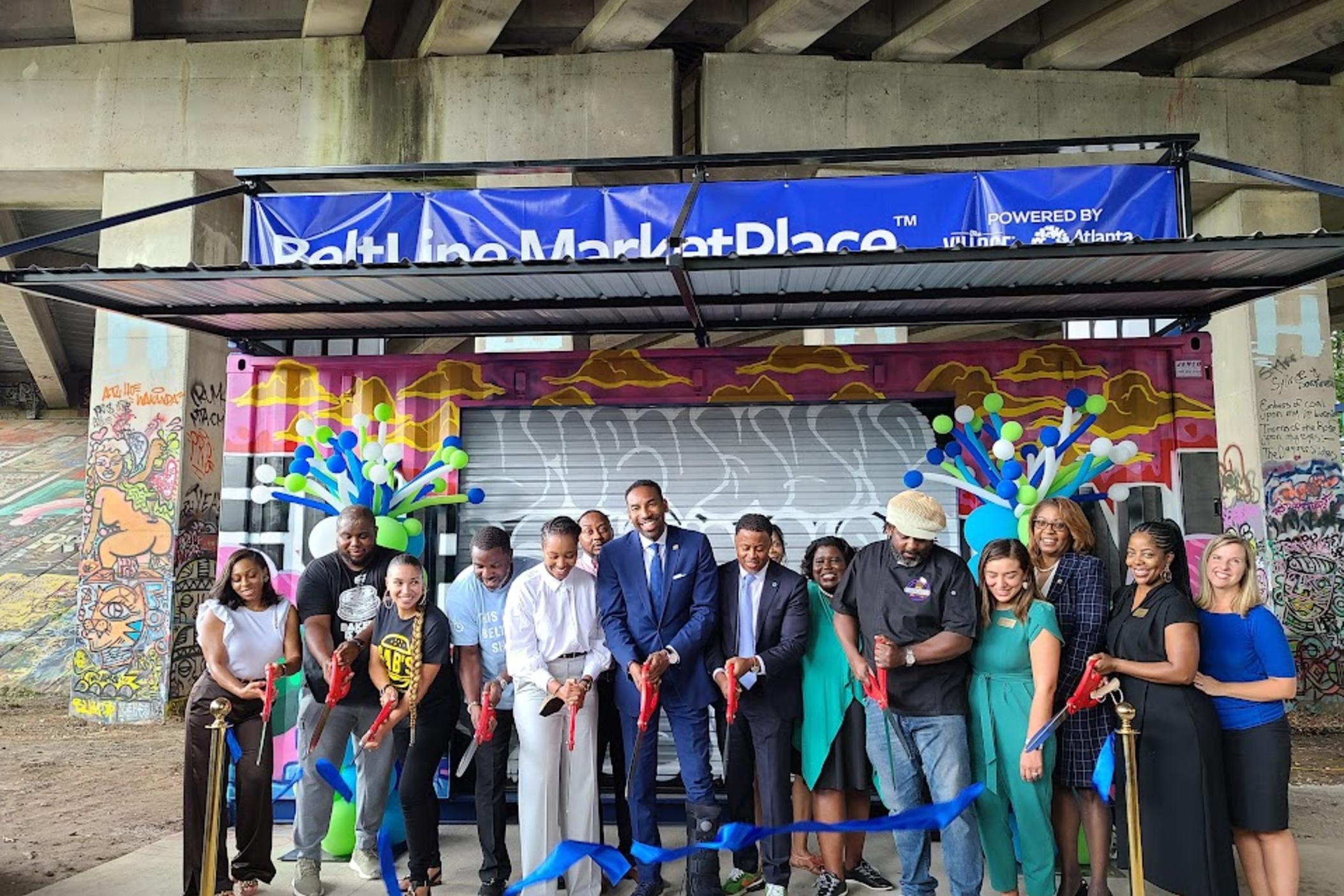 Atlanta Mayor Andre Dickens joins staff and owners of Good As Burgers, one of six businesses at a ribbon cutting for the Beltline Marketplace on July 13, 2022.