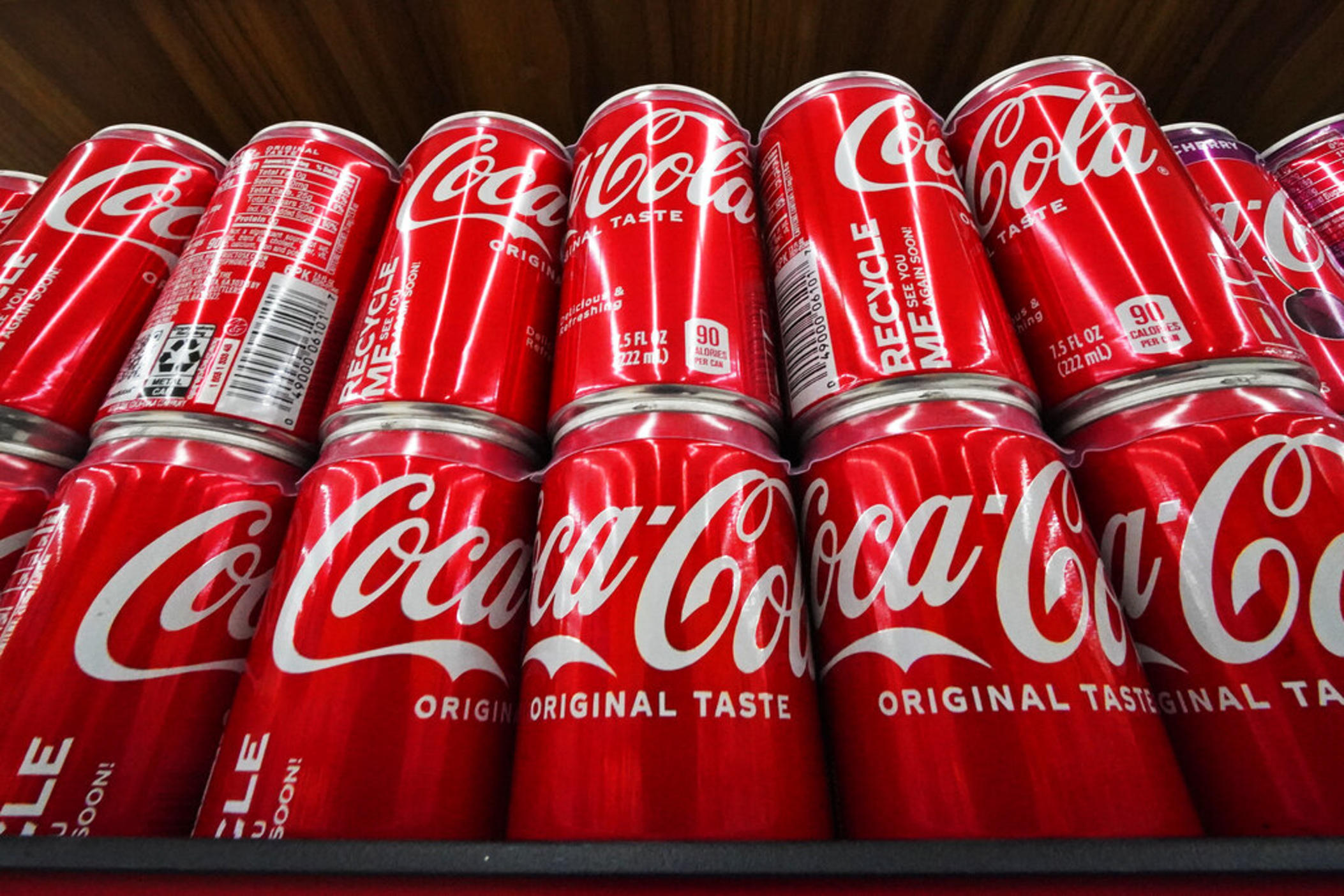 Cans of Coca-Cola are on display at a grocery market in Uniontown, Pa, on Sunday, April 24, 2022. Coca-Cola posted higher-than-expected sales in the second quarter, Tuesday, July 26, due to price increases and continuing improvement in demand at restaurants and other venues. The Atlanta-based company said revenue grew 12% in the April-June period to $11.3 billion.
