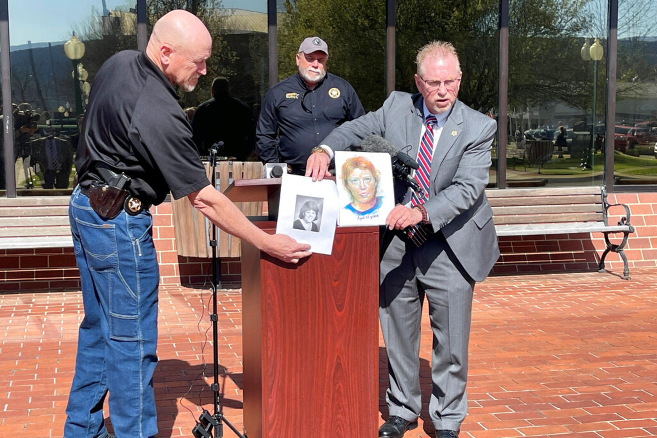 In this photo provided by The Georgia Bureau of Investigation investigators hold a photo of Stacey Lyn Chahorski, left, of Norton Shores, Mich., and a composite sketch of her in Trenton, Ga., March 24, 2022. Georgia and federal officials said on Tuesday, Sept. 6, 2022, that DNA has identified a deceased truck driver as the man who killed the young woman in 1988 in the state's far northwest corner. Officials said genetic genealogy points to Henry Fredrick “Hoss” Wise as the killer of Chahorski.