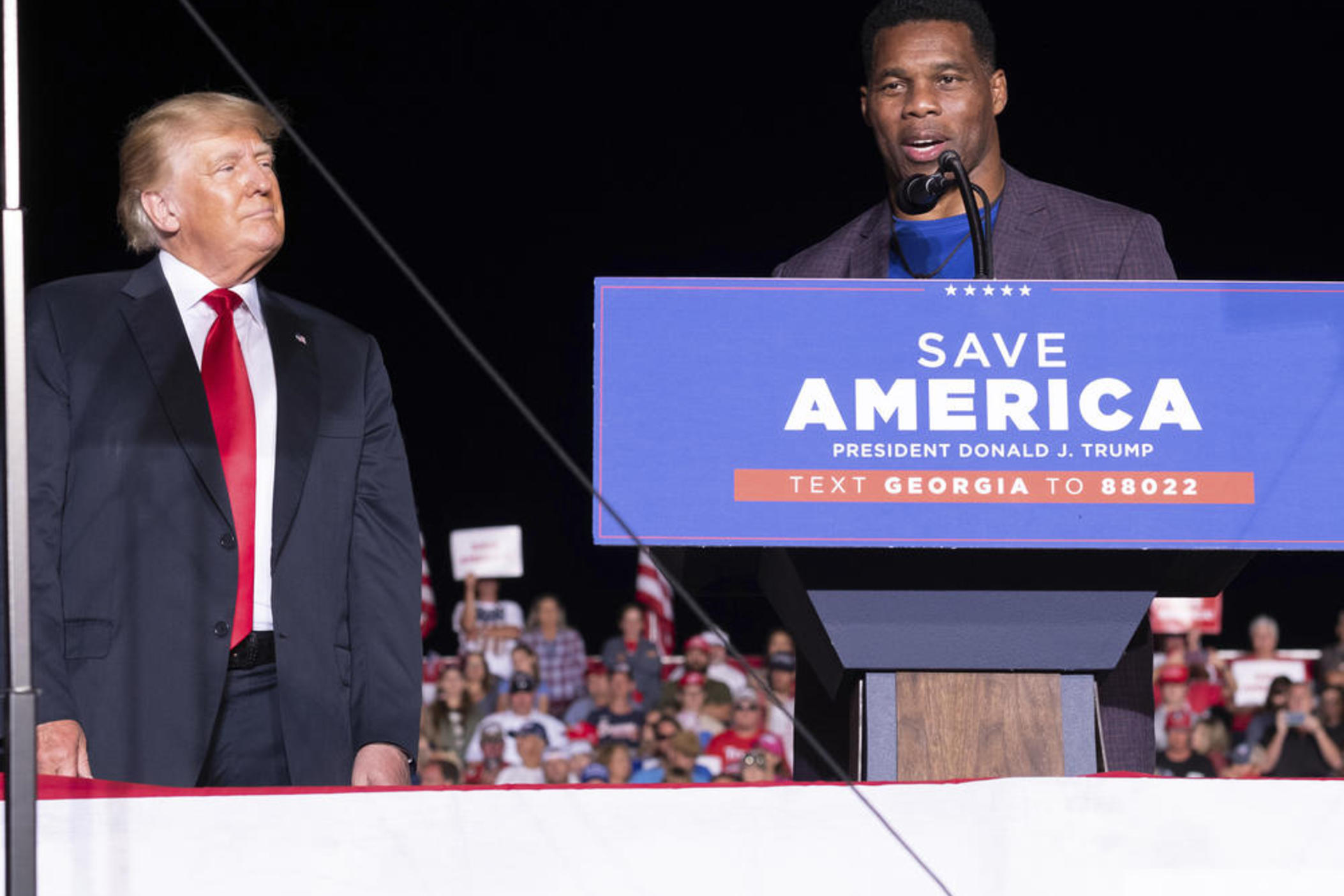 Former President Donald Trump listens as Georgia Senate candidate Herschel Walker speaks during his Save America rally in Perry, Ga., on Saturday, Sept. 25, 2021.