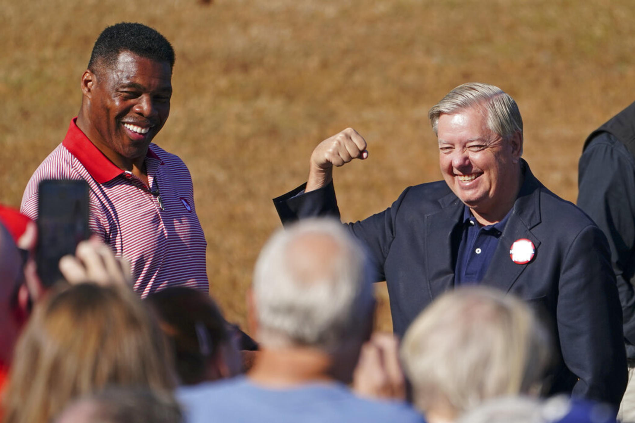 Republican candidate for U.S. Senate Herschel Walker, left, and Sen. Lindsey Graham, R-S.C., gesture to the crowd as they arrive for a campaign stop in Cumming, Ga., Thursday, Oct. 27, 2022.