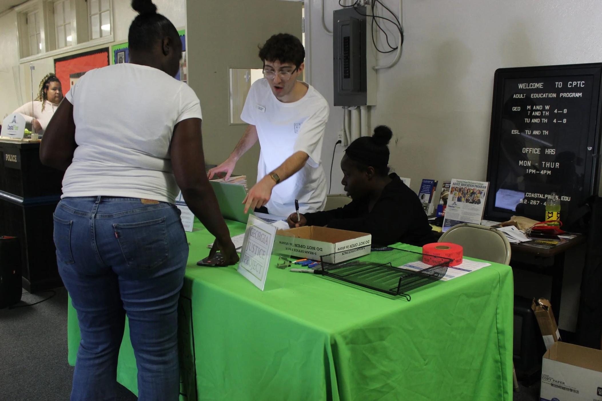 A volunteer with Georgia Justice Project assists a woman at a Brunswick expungement clinic. Credit: Erika Curtis/Georgia Justice Project