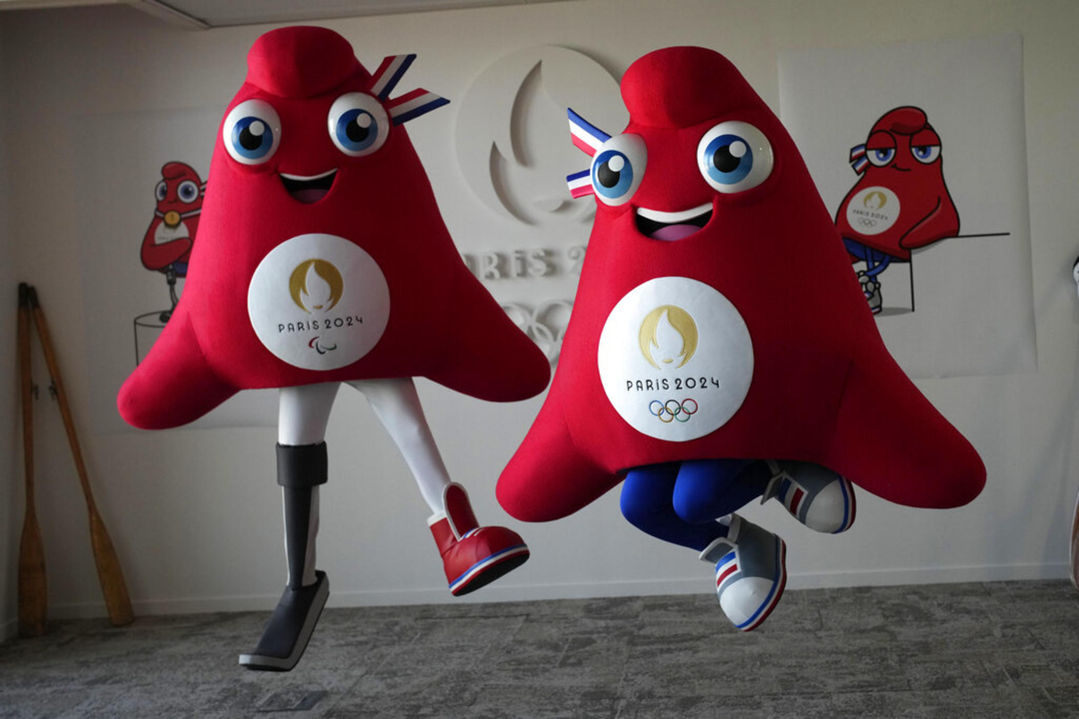 Mascots of the 2024 Paris Olympic Games, right, and Paralympics Games, a Phrygian cap, jump during a preview in Saint Denis, outside Paris, on Thursday, Nov. 10, 2022. Izzy, the much-hated blob that represented the 1996 Atlanta Games has been supplanted by the mascot for the Paris Olympics — a Phrygian cap.