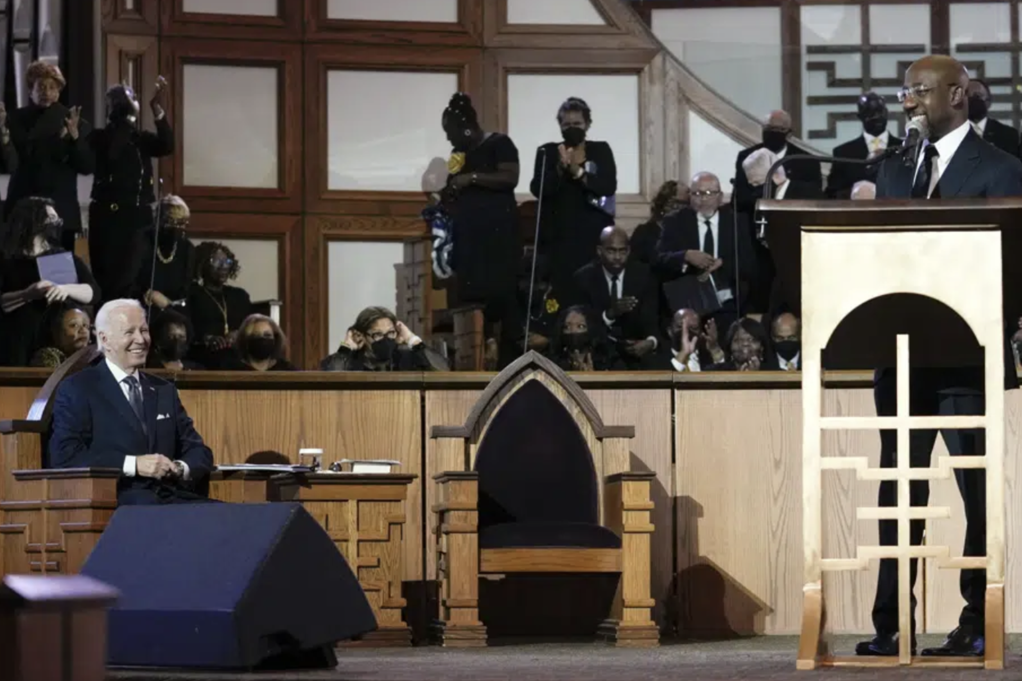 President Joe Biden listens as Sen. Raphael Warnock, D-Ga., a senior pastor at Ebenezer Baptist Church, speaks at Ebenezer Baptist Church in Atlanta, Sunday, Jan. 15, 2023, during a service honoring Martin Luther King Jr. 