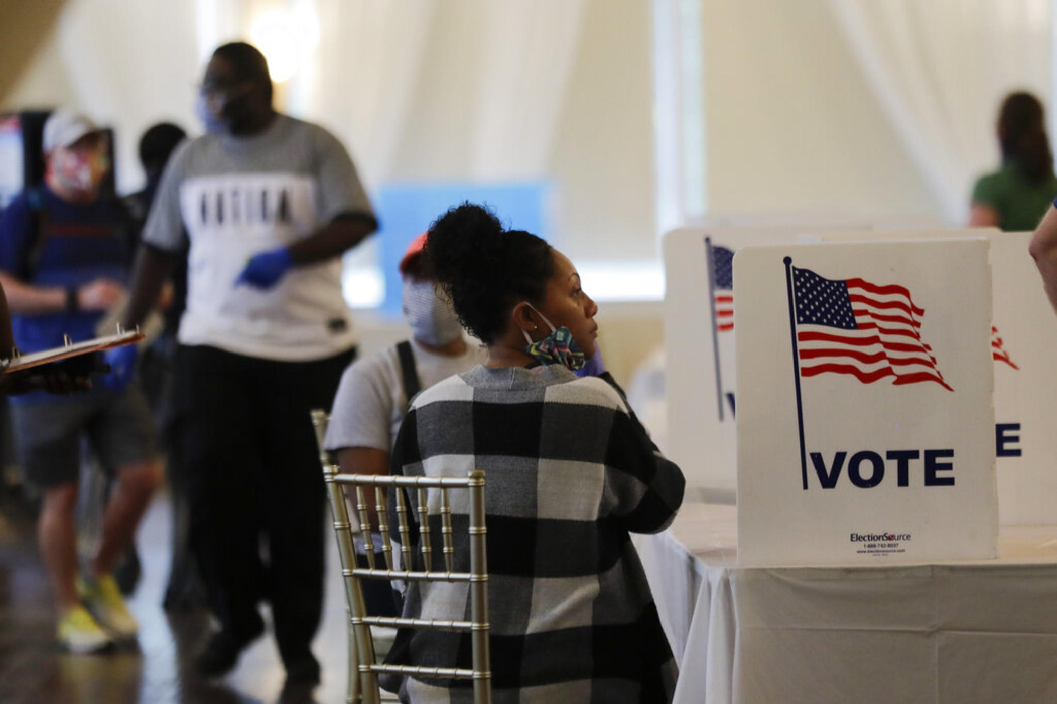 People wait to vote in the Georgia's primary election at Park Tavern on June 9, 2020, in Atlanta. A process recently implemented by Georgia state lawmakers to examine how county officials handle elections is likely unsustainable without more resources or reforms, according to the panel that did the first review under the law. 