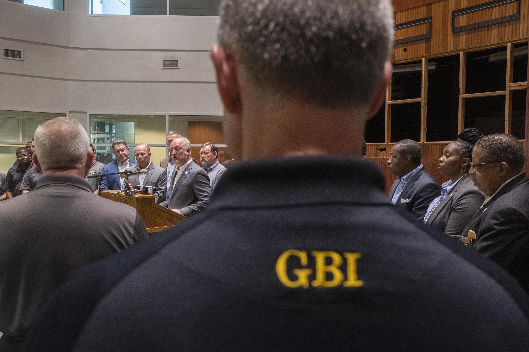 Macon-Bibb County Mayor Lester Miller, at the podium, is flanked by GBI Director Michael Register, center left, other GBI investigators, federal prosecutors and local law enforcement during the announcement of the GBI middle Georgia region's gang task force headquarterds Wednesday. 