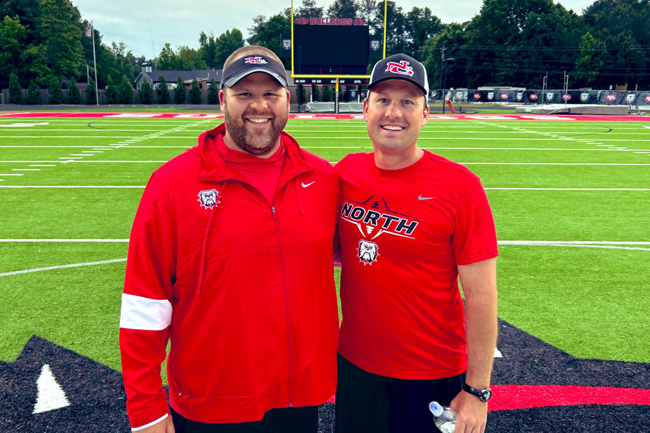 New North Gwinnett High School football coach Eric Godfree (right) and offensive line coach Nick Johnson (left) during the Bulldogs spring practice in May. 