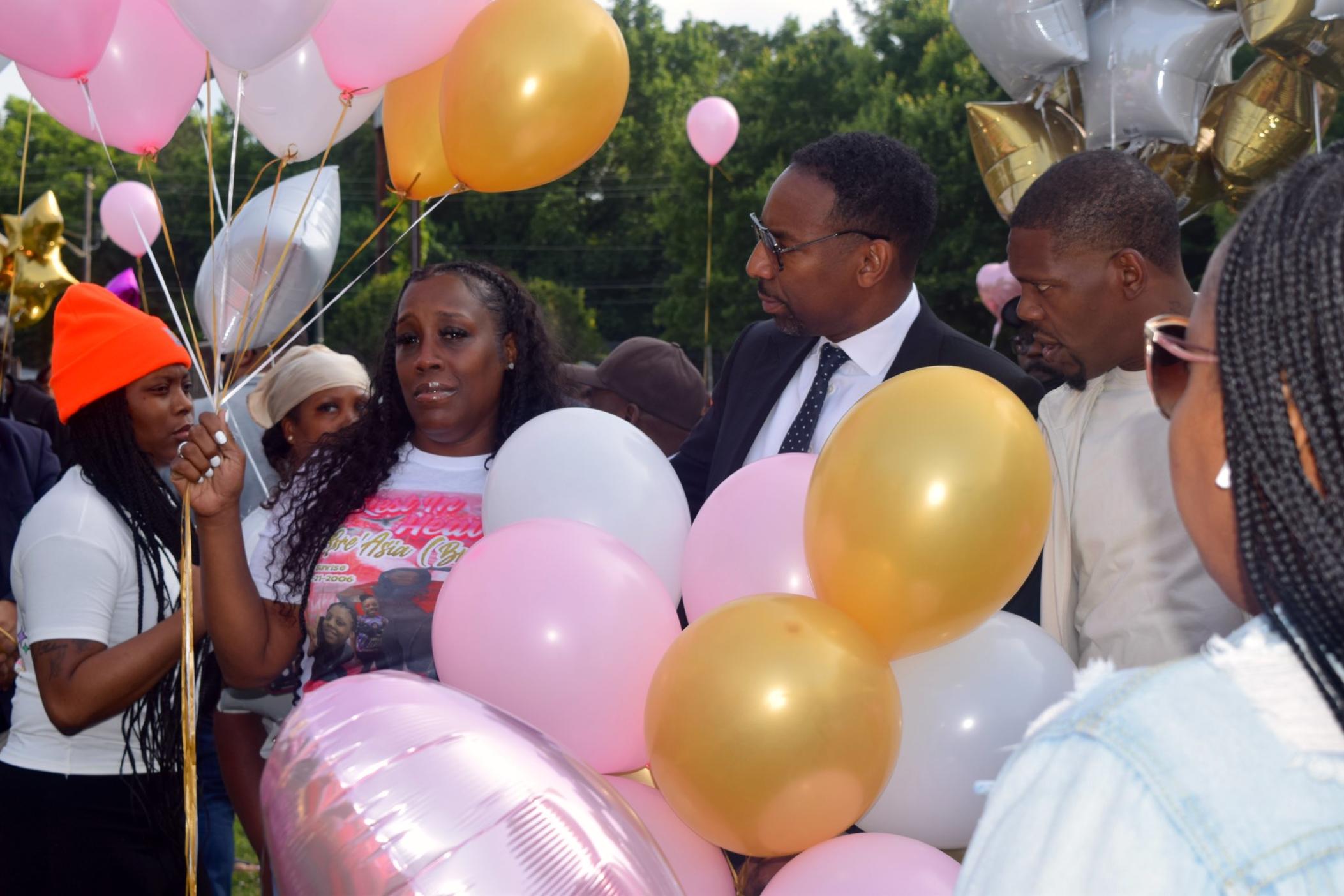 Nicole Williams, mother of Bre'Asia Powell, who died after being shot at a gathering on the grounds of Benjamin E. Mays High School Sunday, holds balloons a May 31 balloon release in honor of her 16-year-old daughter. Atlanta Mayor Andre Dickens (center) spoke at the event.