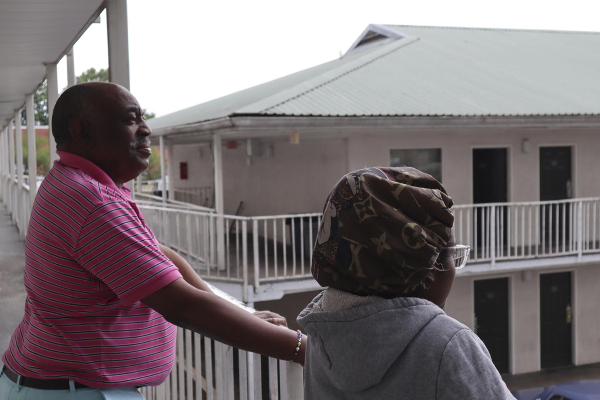 Dana Williams and his daughter De'mai Williams stand outside a low-cost hotel in Atlanta on May 18, 2023. The two have been looking for an affordable place to live ever since they were evicted from their two-bedroom apartment in April. 