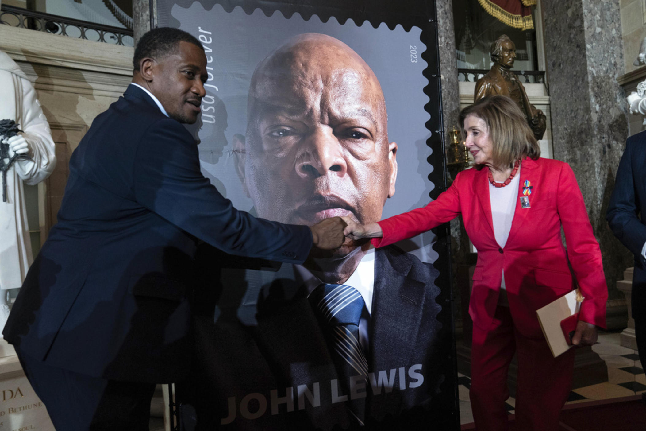 Rep. Nancy Pelosi D-Calif., shake hands with Michael Collins during the stamp unveiling ceremony for Rep. John Lewis on Capitol Hill, Wednesday, June 21, 2023, in Washington. 