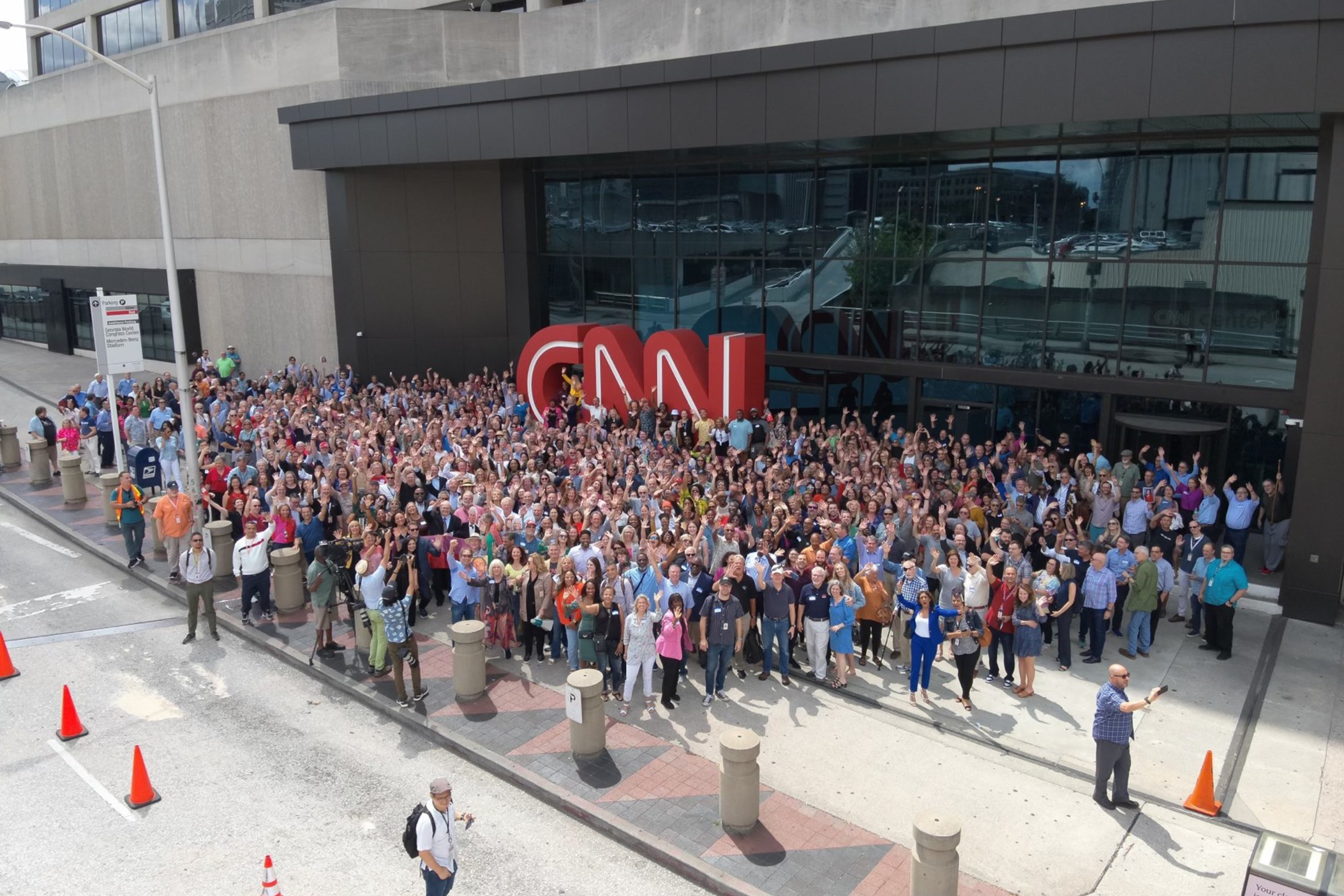 Current and former CNN employees gather in front of the iconic red letters on June 1, 2023 to mark the network's 43 years. The sign will be moved to the company's Techwood location this year.