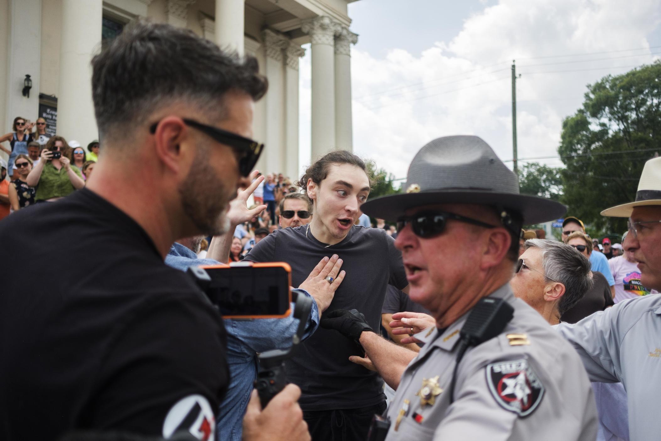 A supporter of Macon's Temple Beth Israel, center, is held back by law enforcement as the leader of a documented antisemitic hate group, left, attempts to disrupt a gathering at the temple on Saturday, June 24. The gathering was in response to the hate group's action at the temple the day before at the start of the Jewish Sabbath.
