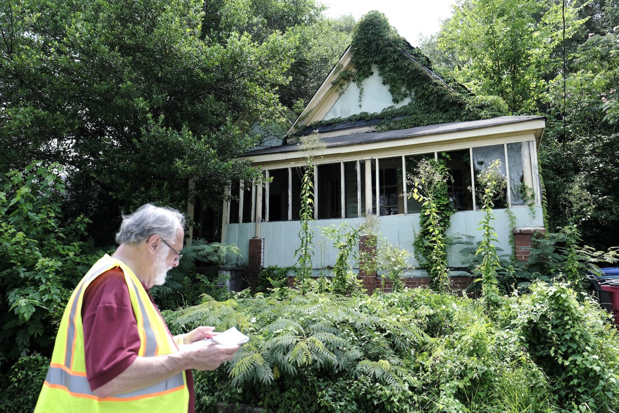 Community volunteer Friar Steven Pavignan fills out a safety survey for a blighted house in the Pleasant Hill neighborhood for the Safe by Design project on June 24, 2023, in Macon, Ga.