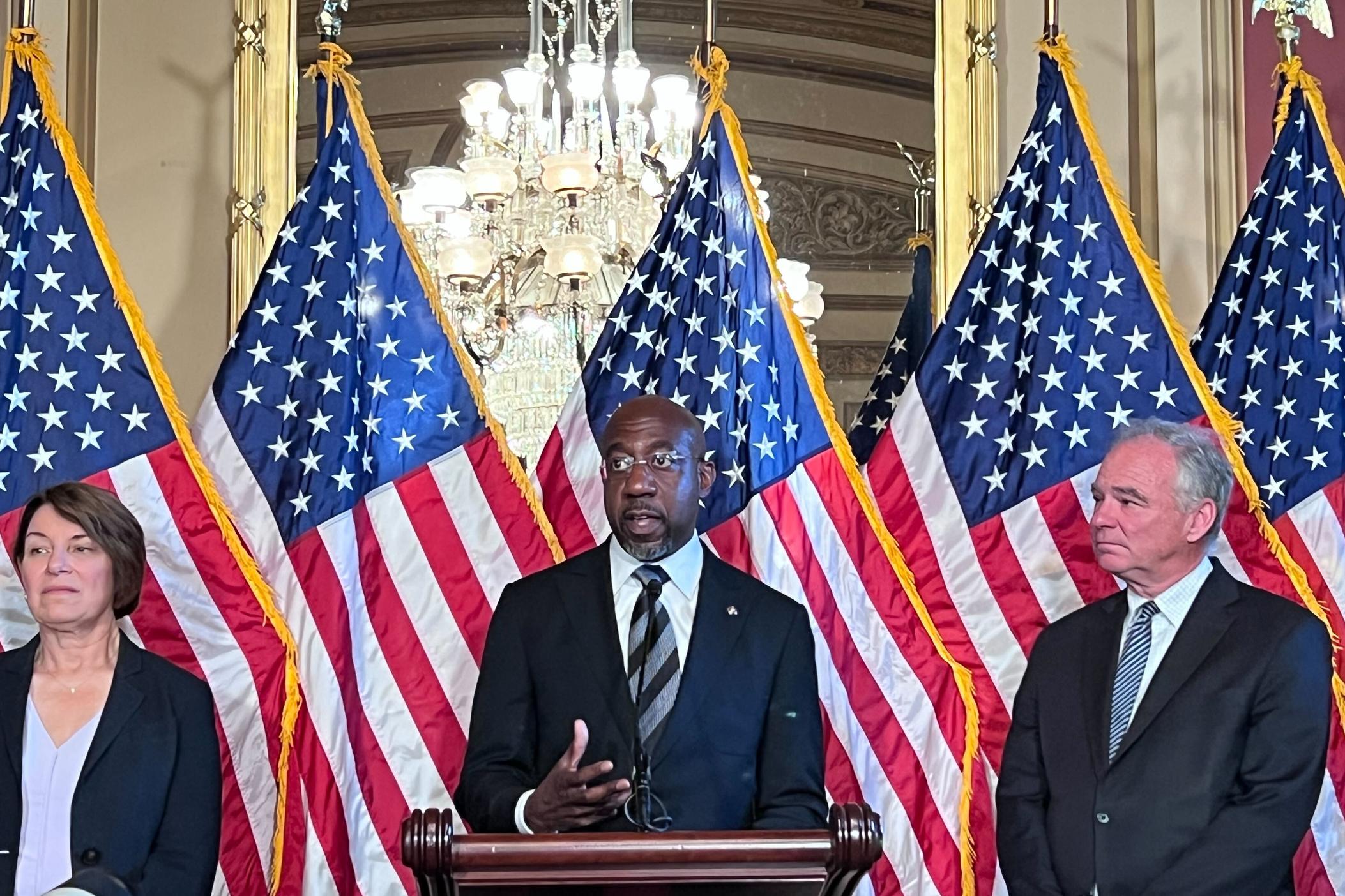 Sen. Raphael Warnock (center) is pictured with fellow senators in a July 18 photo. Warnock reintroduced the Preventing Election Subversion Act on Thursday, July 27, 2023.