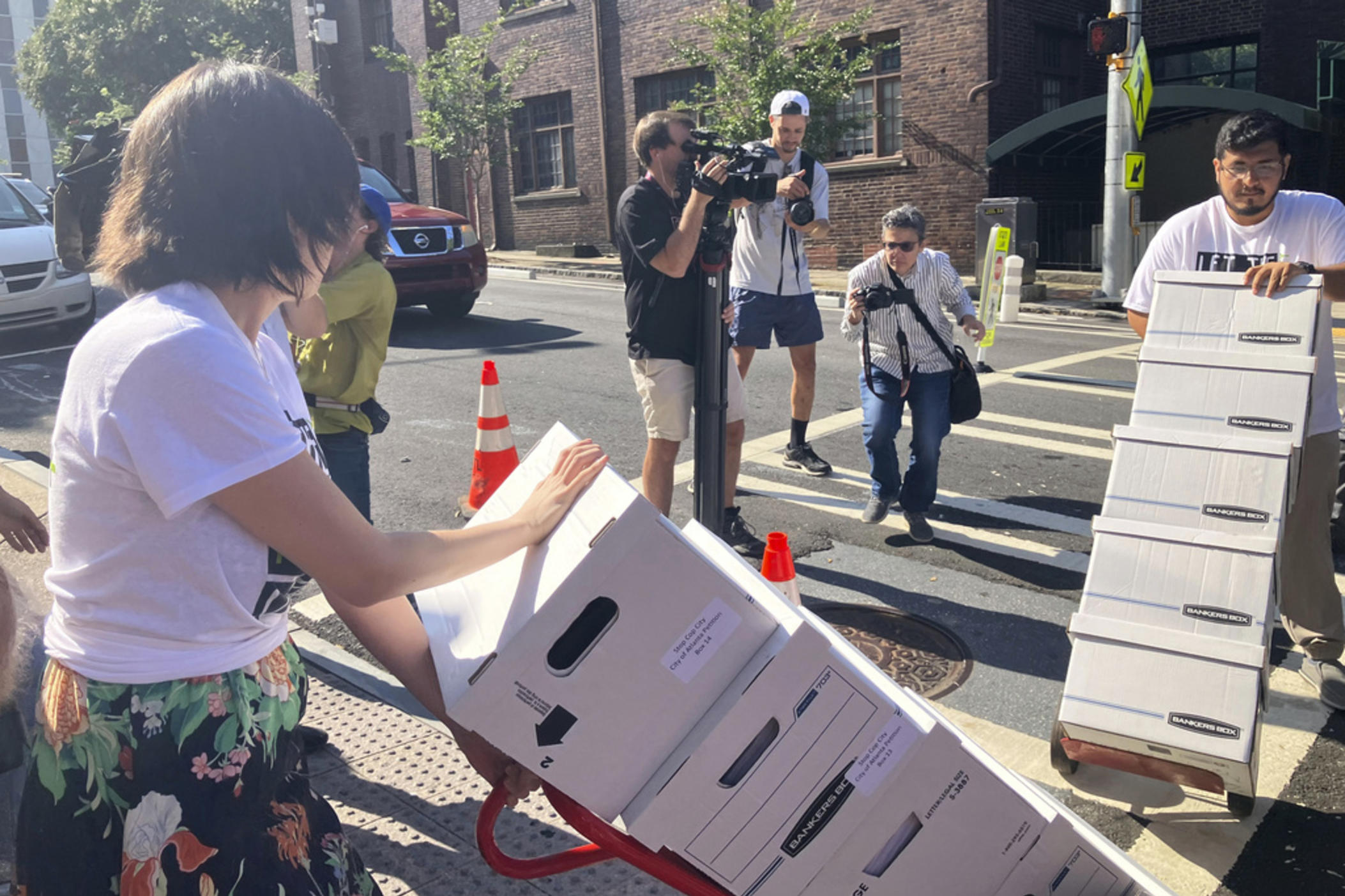 Activists haul dozens of boxes full of signed petitions to Atlanta City Hall, Monday, Sept. 11, 2023, to force a referendum on the future of a planned police and firefighter training center. Shortly after, though, Atlanta officials refused to accept the paperwork for processing, saying the city is awaiting a court decision over whether the petitions had been turned in on time.